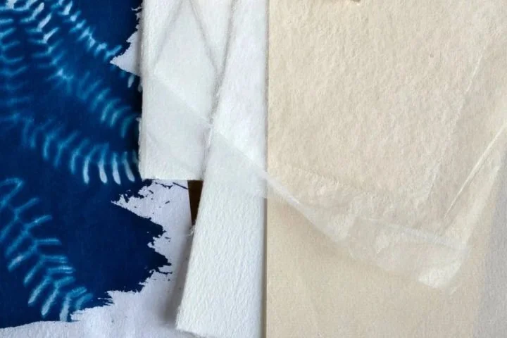 Un mix de papiers de couleur blanc et beige avec un tirage cyanotype.