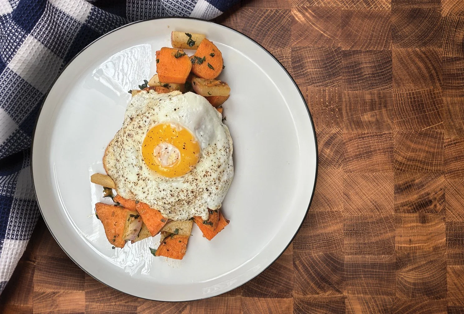 Baked dish with sliced almonds on top, in a rectangular white ceramic baking dish placed on a wooden surface.