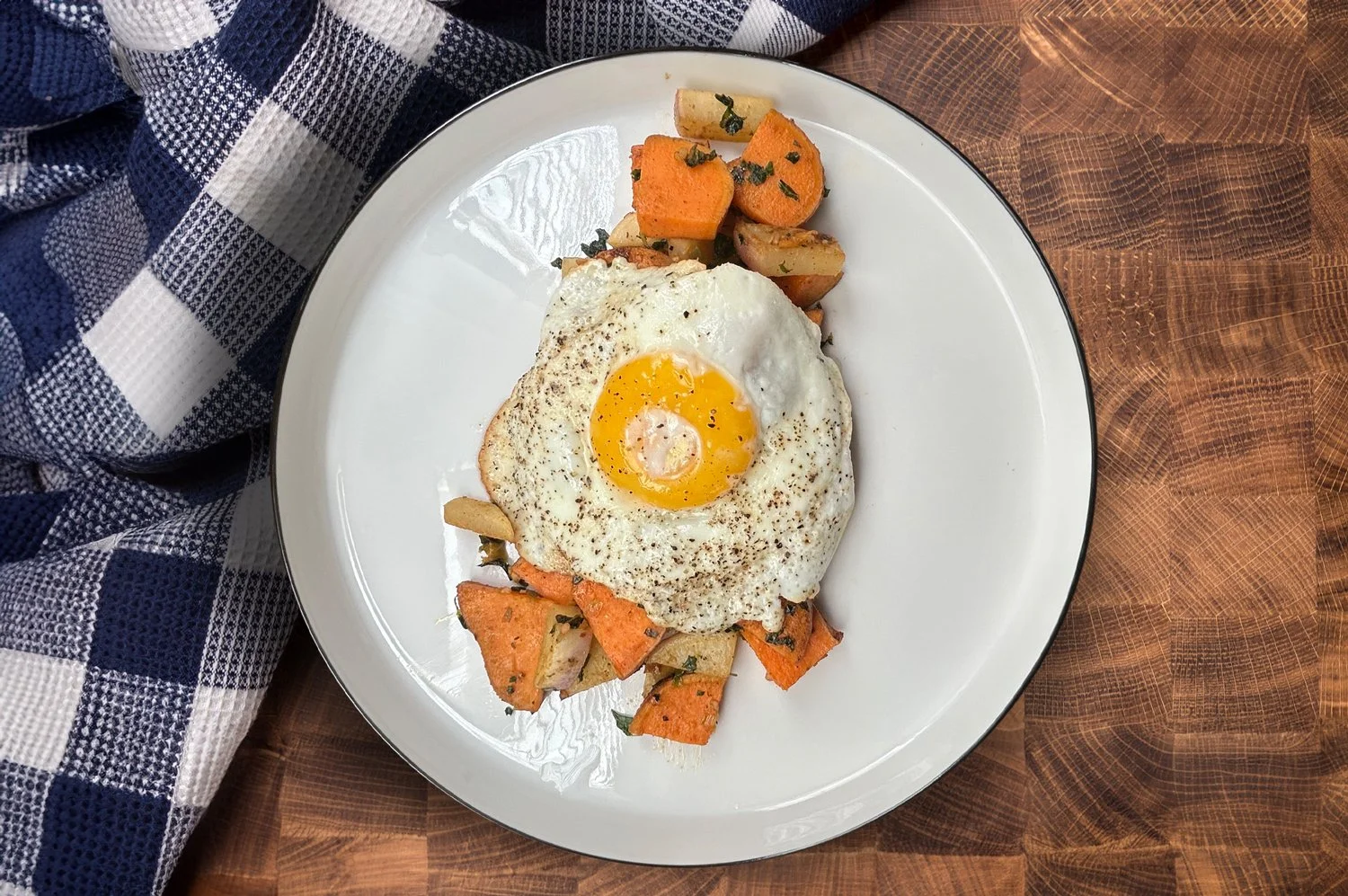 Baked dish with sliced almonds on top, in a rectangular white ceramic baking dish placed on a wooden surface.