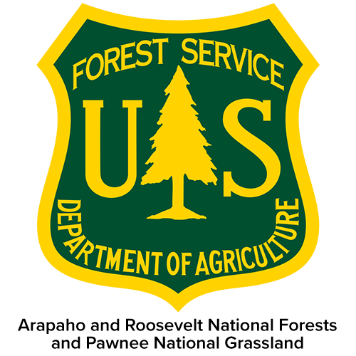 U.S. Forest Service badge with a green shield, yellow border, and a pine tree in the center. Text includes "Forest Service," "U.S.," and "Department of Agriculture."