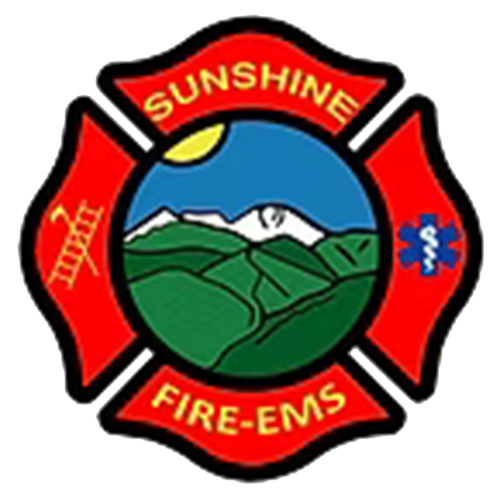 Firefighter badge with a mountain and sun in the center and the words "Sunshine" and "Fire-EMS."