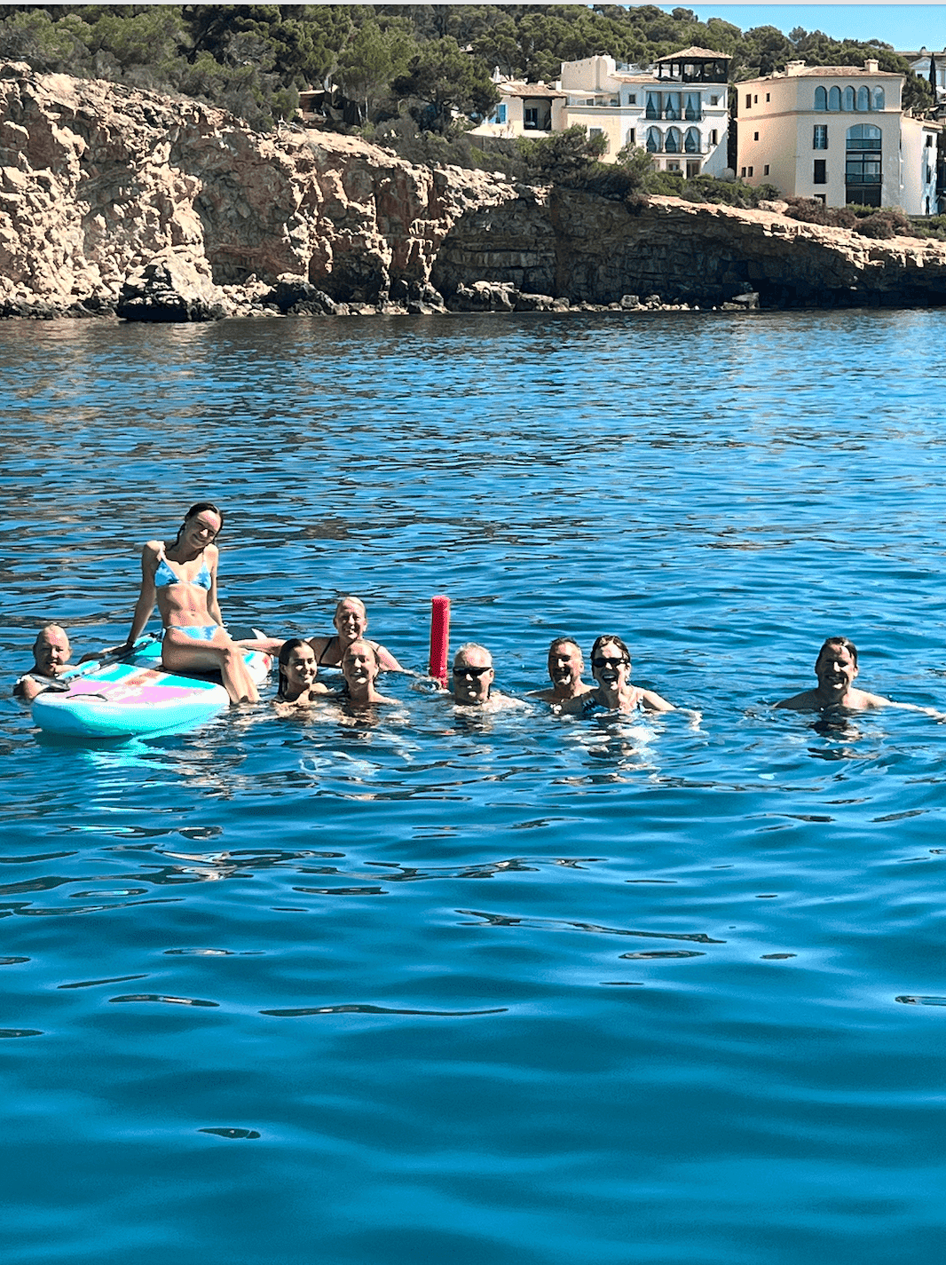 group-of-people-swimming-on crystal clear water with paddleboard
