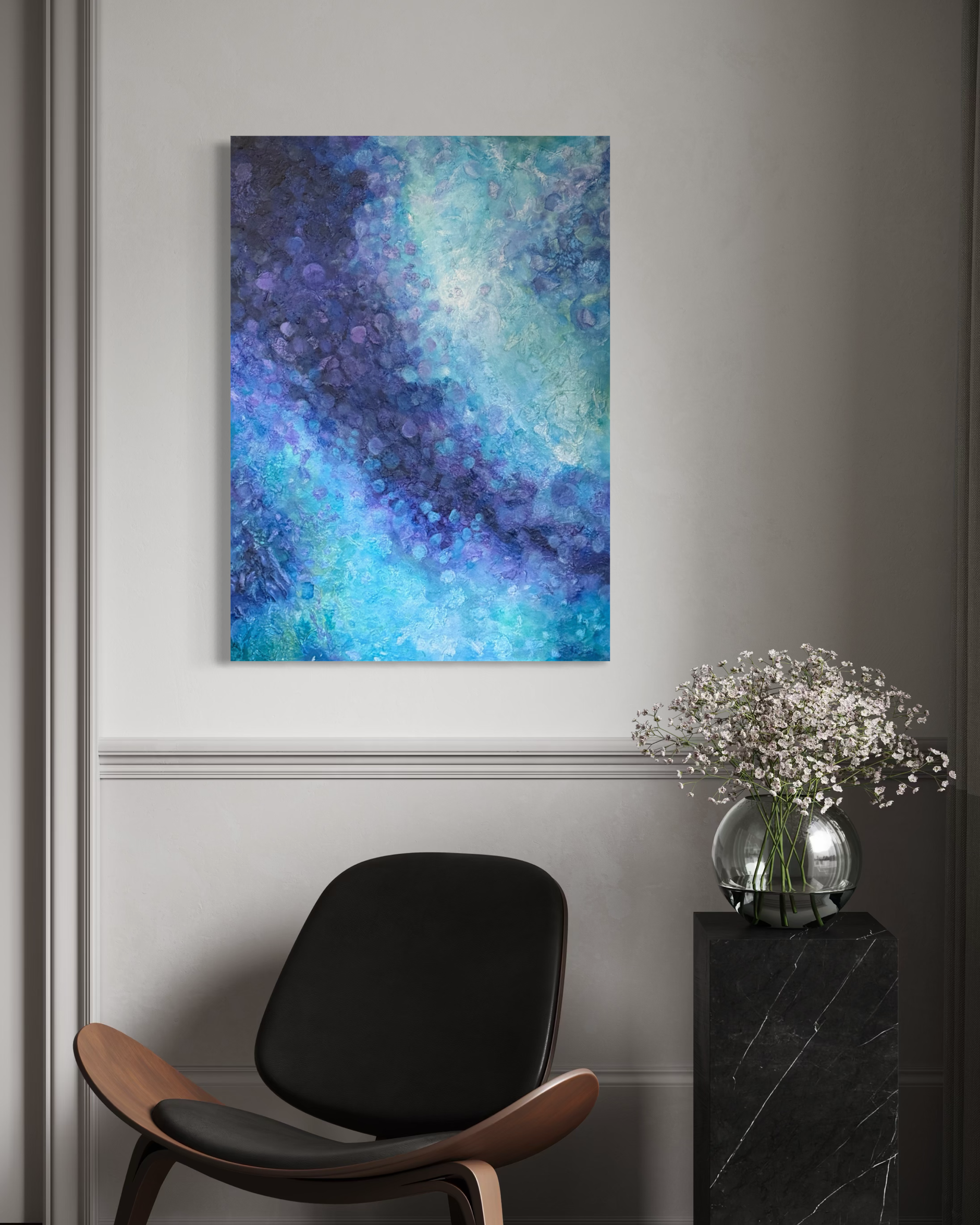 A modern interior space featuring a white wall with a colorful abstract painting, a black and wooden lounge chair, a black marble side table, and a vase of white flowers.