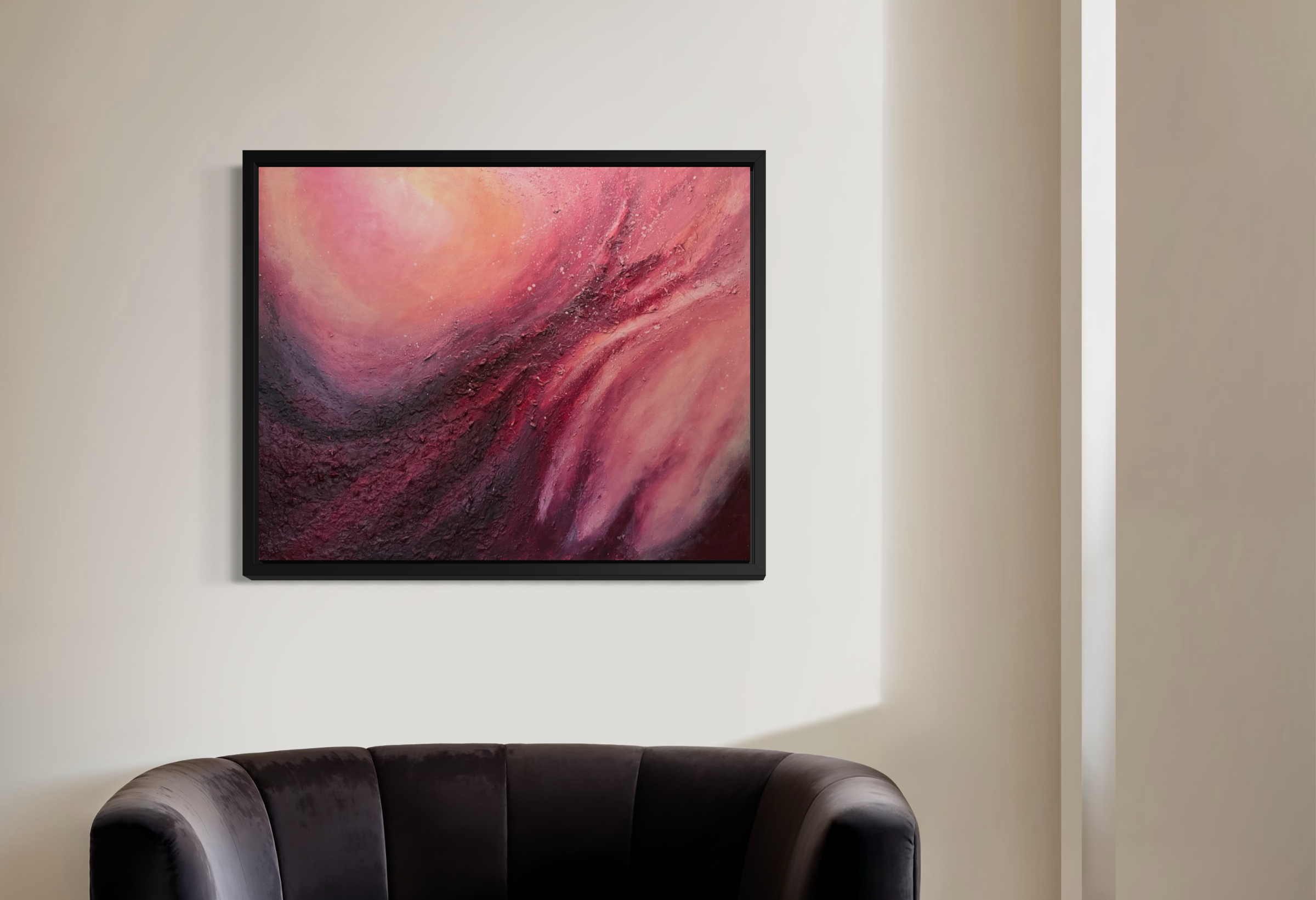A modern living room with a large abstract pink and red painting on the wall, a dark leather couch in the foreground, and a beige wall with a white structural element to the right.