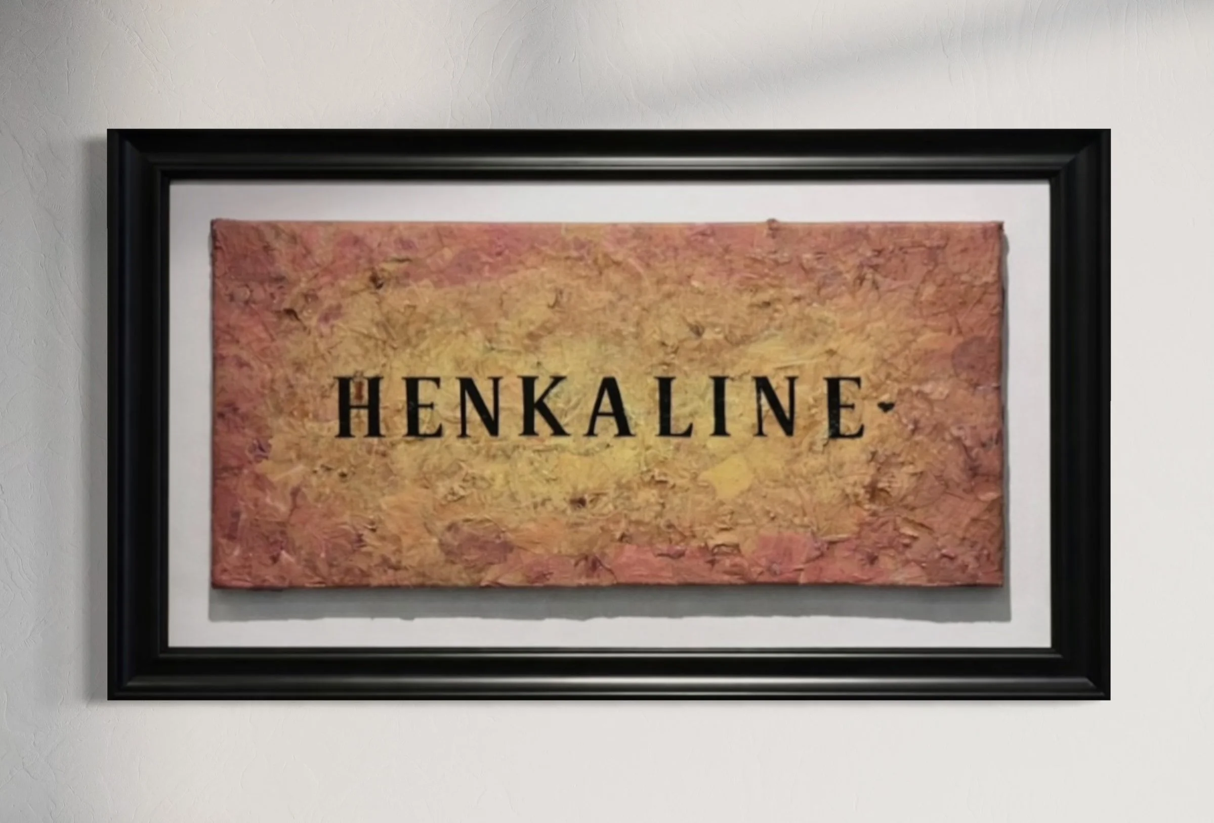 Framed artwork with the word 'HENKALINE' in black letters over an orange, yellow, and pink textured background.