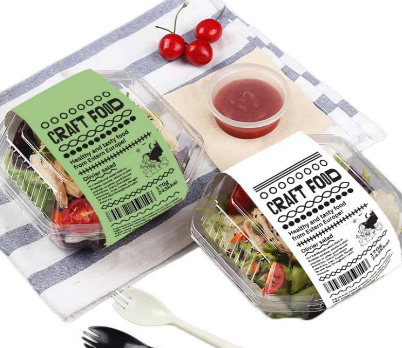 Pre-packaged salads labeled 'Craft Food' with a small container of salad dressing, cherry tomatoes, and black and white forks on a checkered cloth.