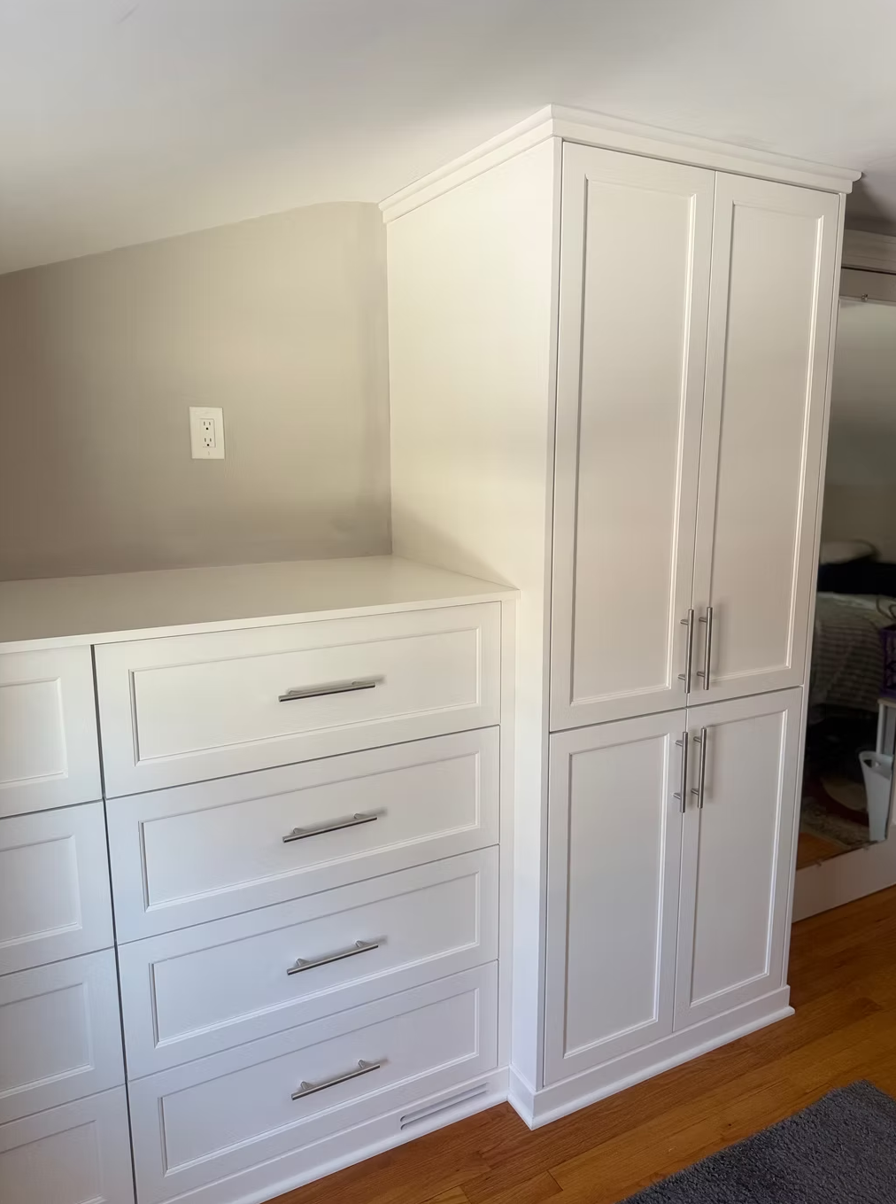 White cabinetry with drawers and closet doors in a room.
