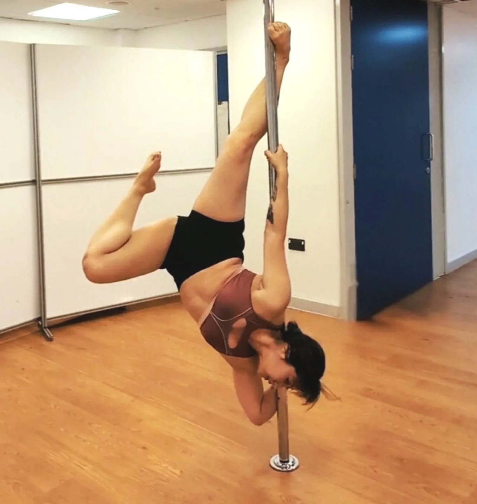 Harris Wong, pole fitness practitioner performing a drill
