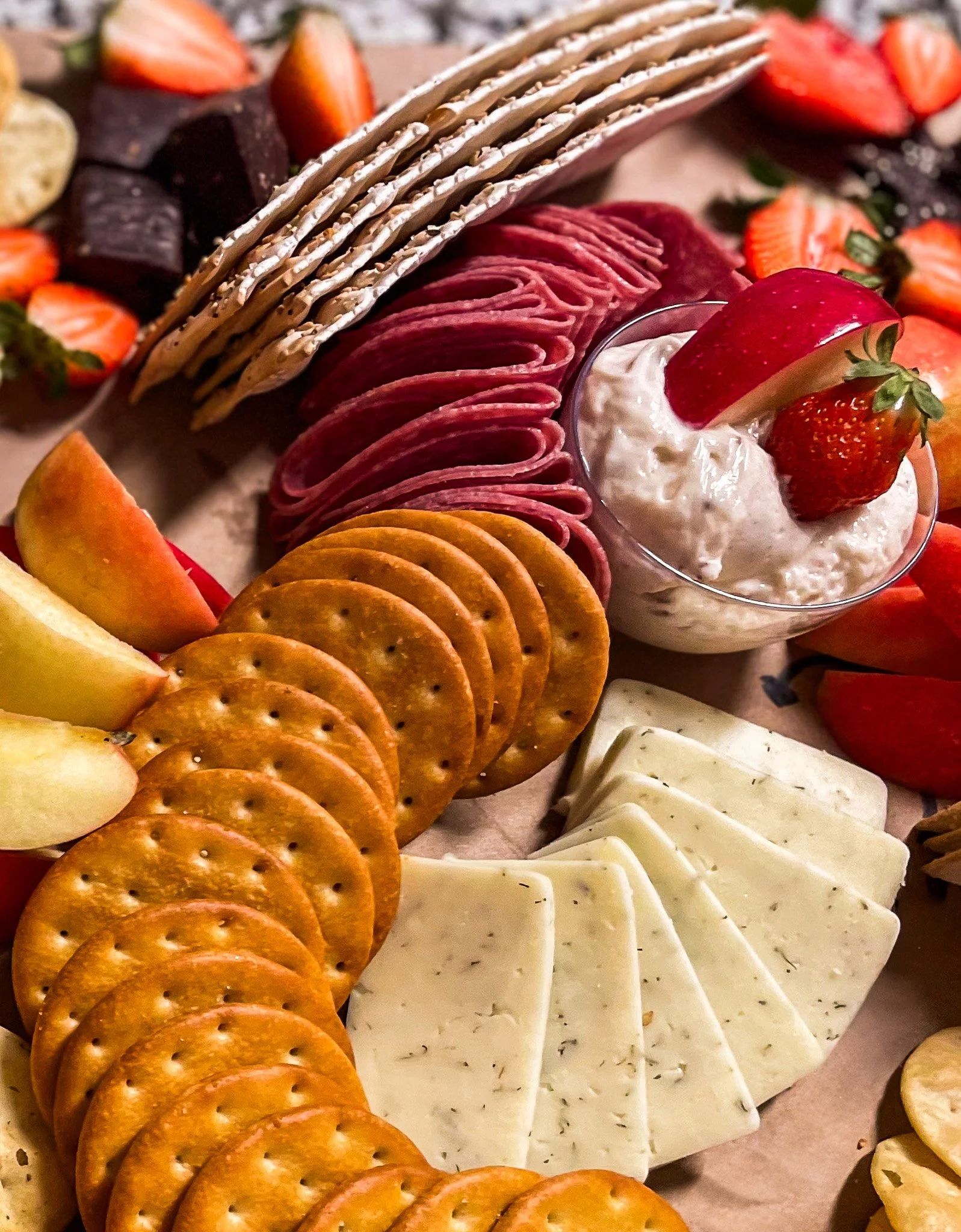 Charcuterie with fruit, dips, crackers, meats, cheeses, and chocolates
