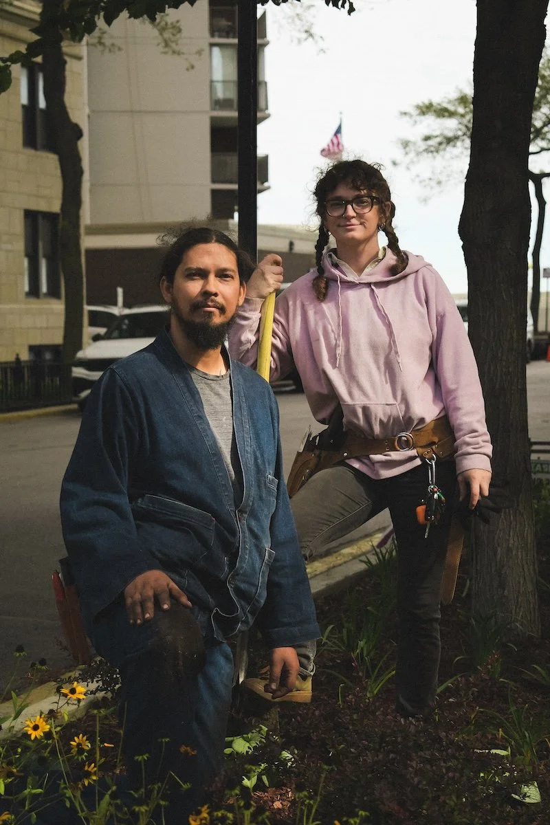 home grown botanical design gardeners Cat and Adam, posed with gardening gear in front of a planted parkway