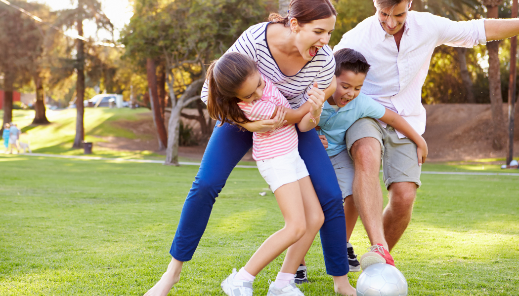 Family playing soccer outdoors, symbolizing restored mobility and healthy living after effective spine or neurological care with Level One Neurosurgery.