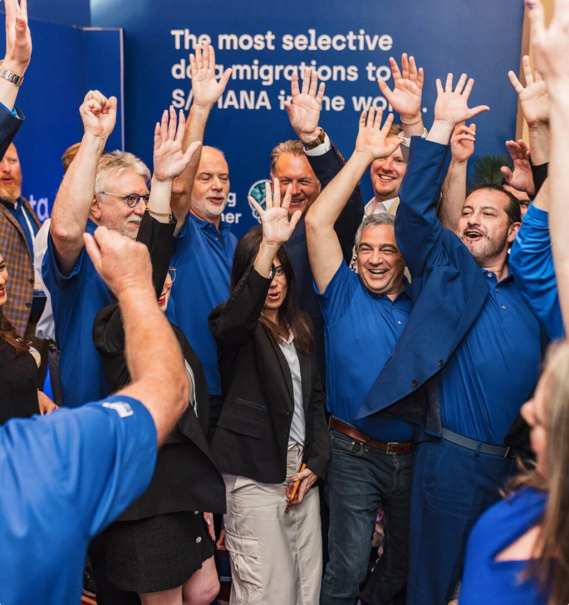 Group of people celebrating with raised hands, some wearing blue shirts, in front of a blue background with white text about demographic shifts.