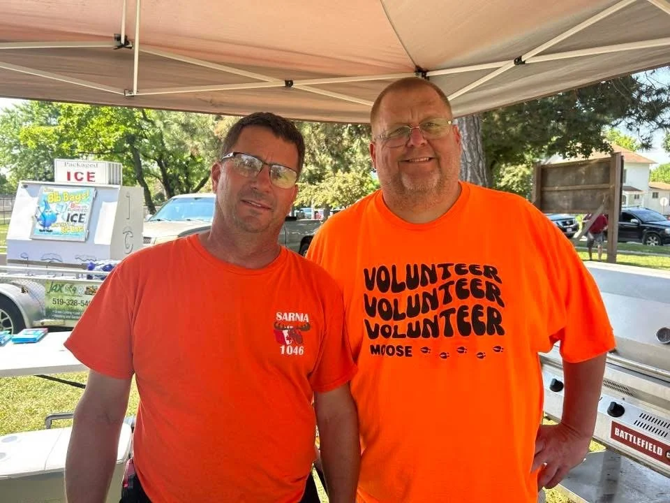 These guys cooking hotdogs and working the food table.