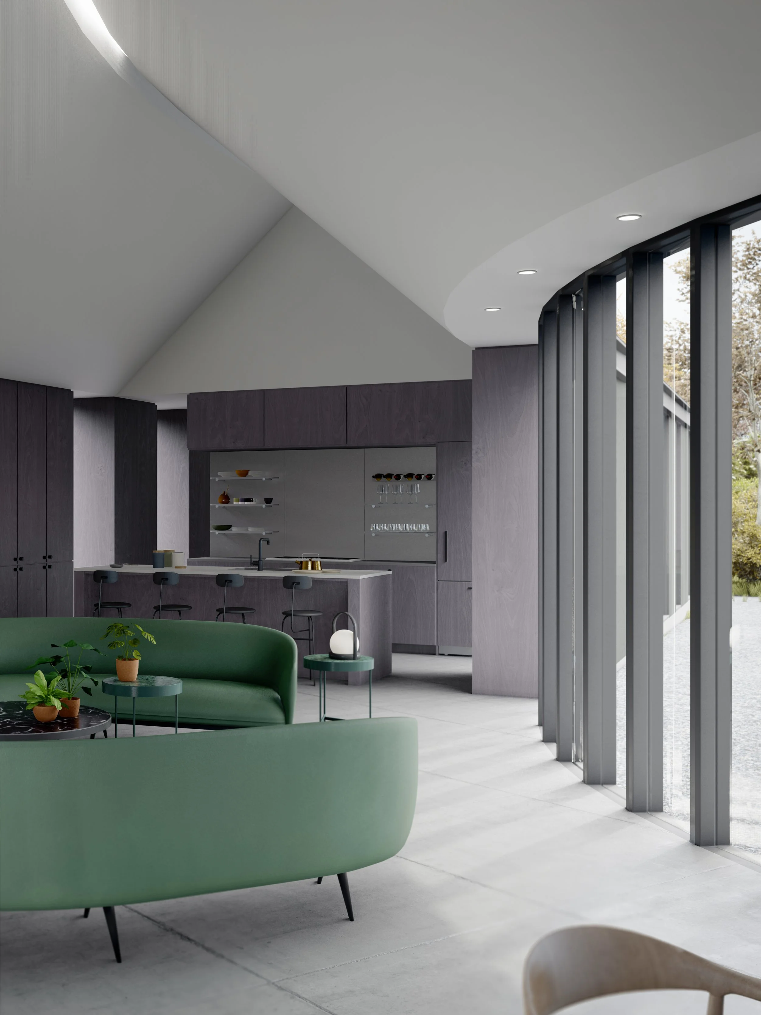 The interior of the Y House has a green sofa, small green tables with potted plants, and a kitchen area with dark cabinetry and bar stools, and large floor-to-ceiling windows with views of outdoors.