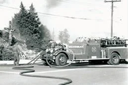 Firefighter inspecting a damaged fire truck after an accident