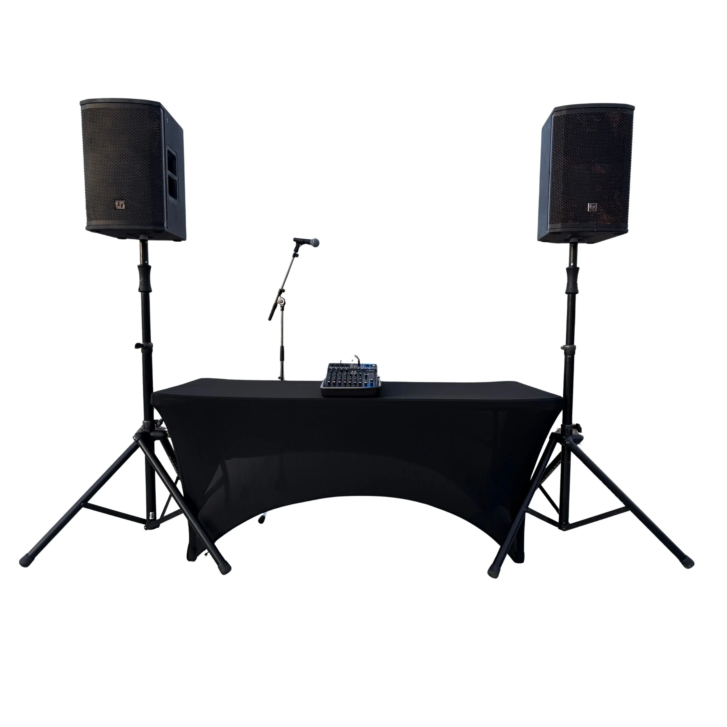 DJ setup with two large speakers on stands, a mixing console, a microphone, and a table draped with black cloth, all arranged for a performance or event.