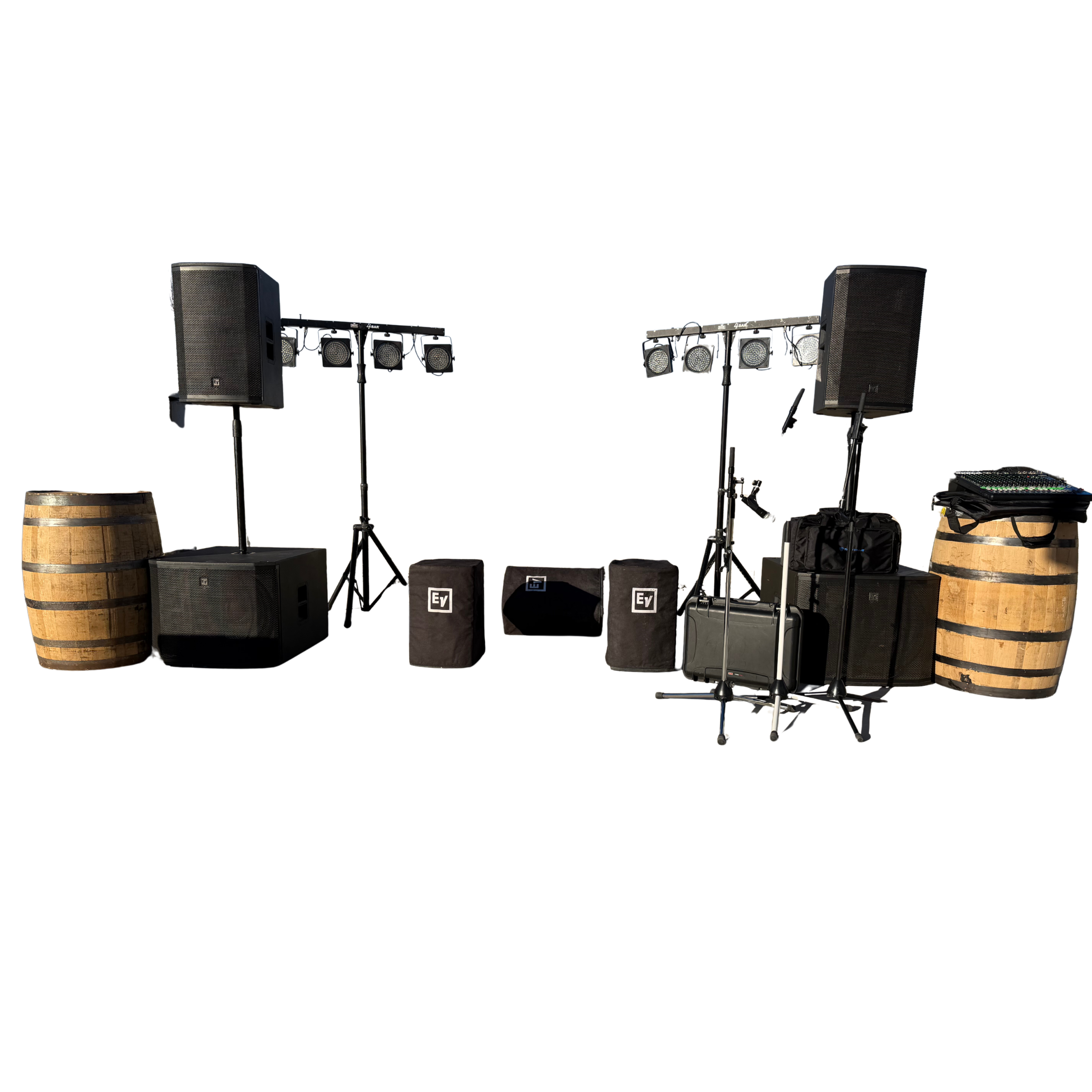 Audio equipment setup including speakers, microphones, lighting, and equipment cases on a stage with barrels as decorative elements.