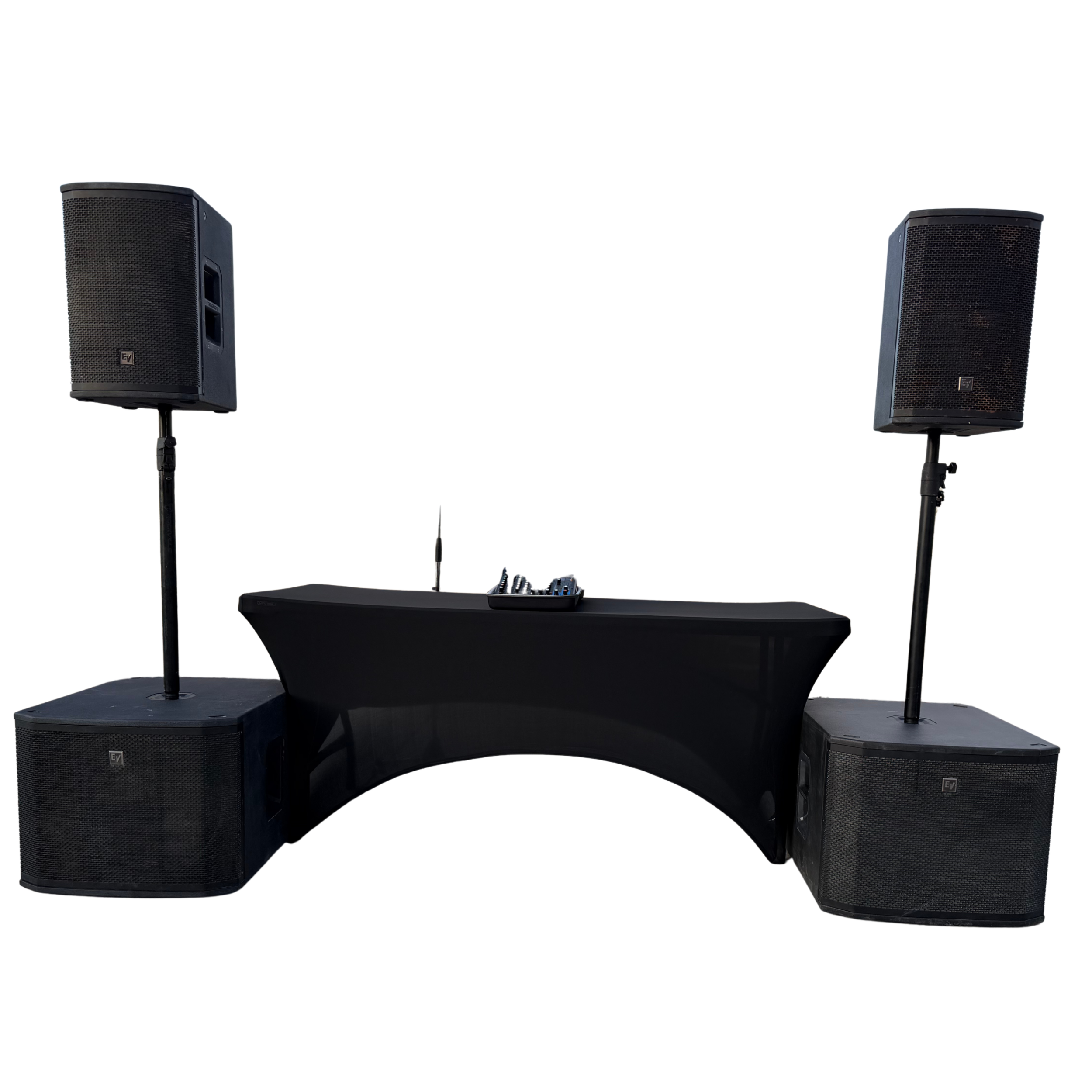 Dance floor speaker system with two large black speakers on stands, placed on sides of a black DJ table with equipment, against a white background.