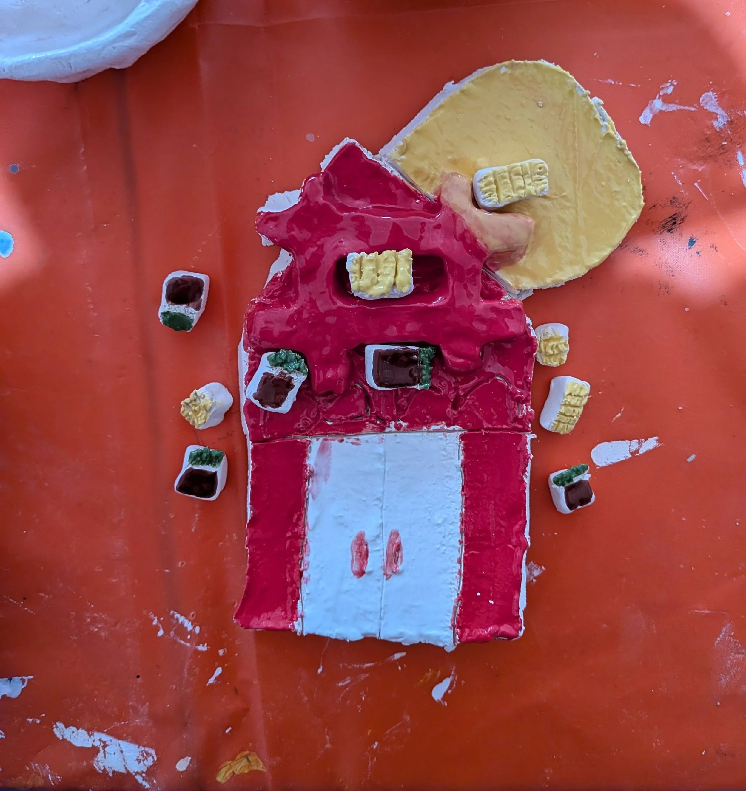Christmas-themed craft project resembling a decorated Christmas tree with surrounding presents on an orange table.
