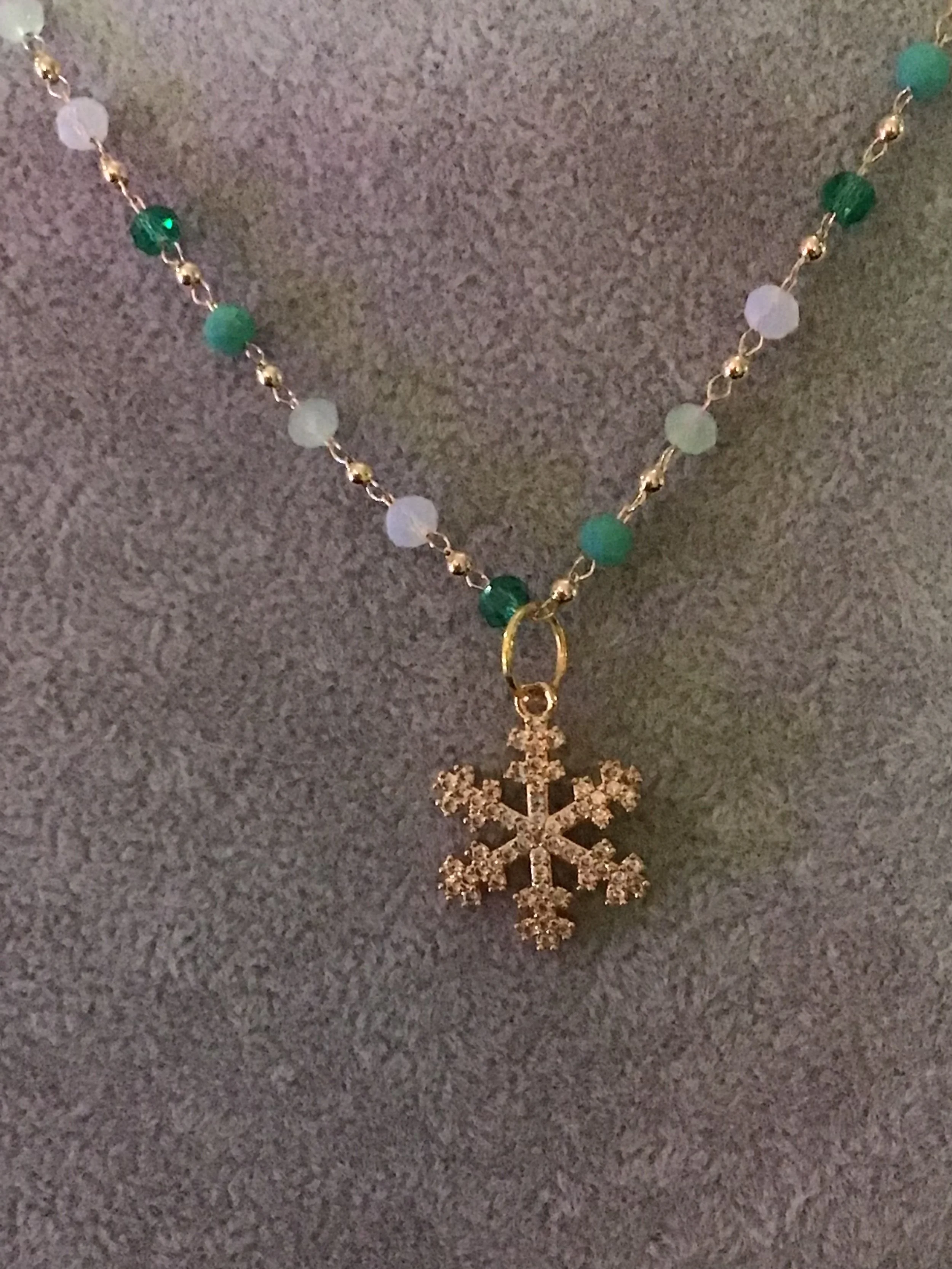 Single strand crystal chain necklace with snowflake pendant.