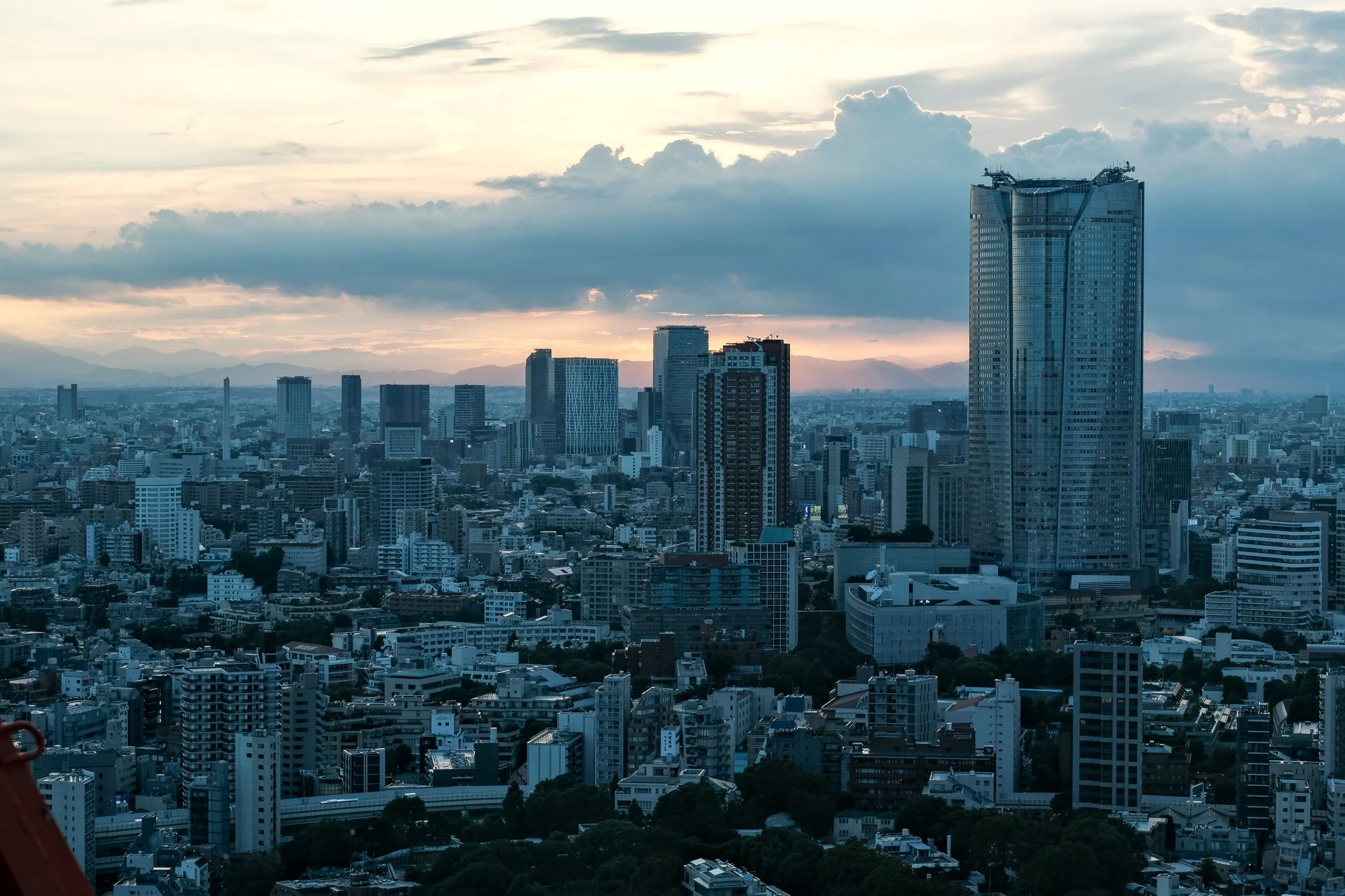 Stadtansicht mit Hochhäusern und Wolken am Himmel bei Sonnenuntergang