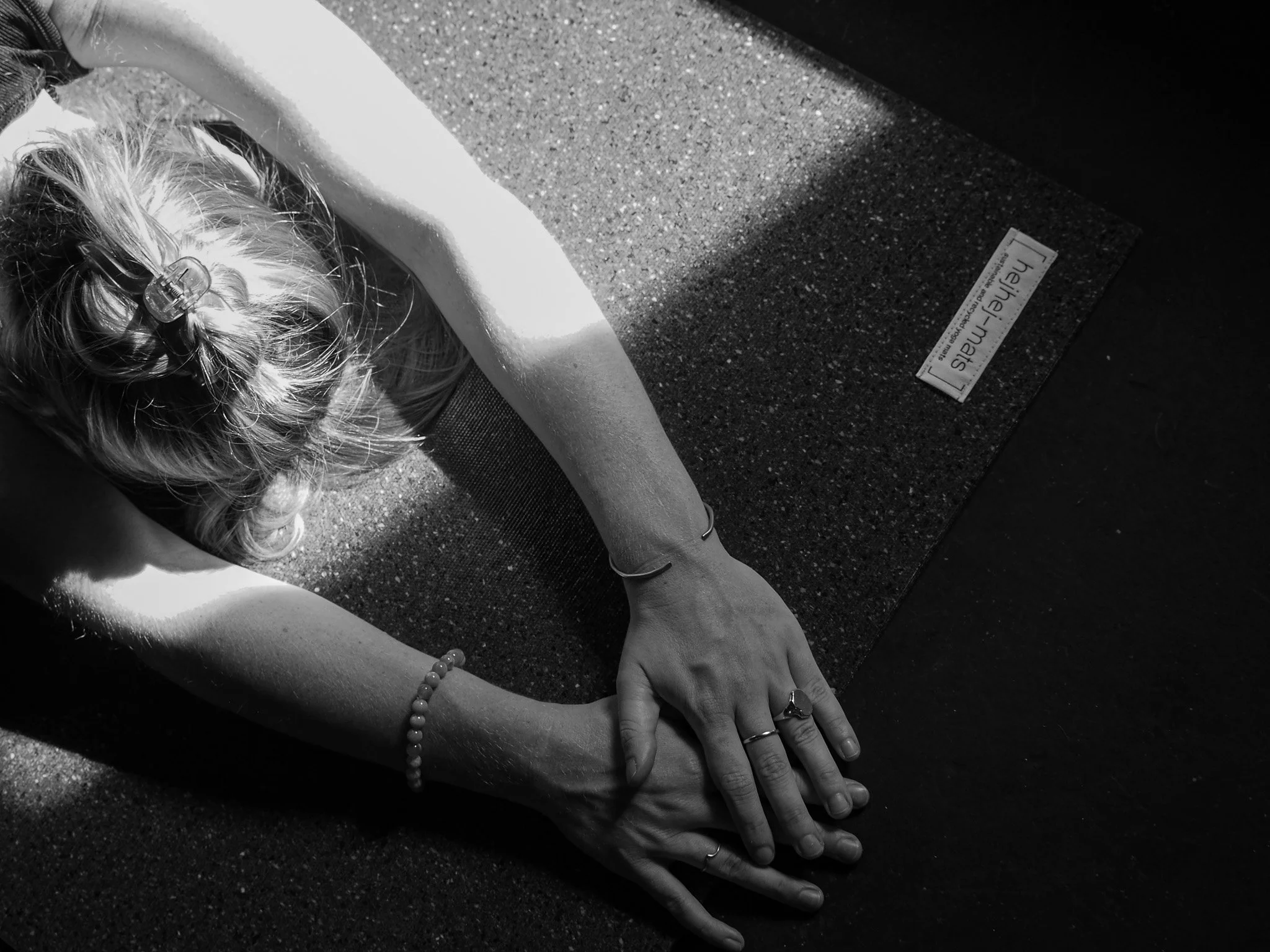 Eine Person macht Yoga-Übung auf einer rutschfesten Matte, die auf dem Boden liegt.