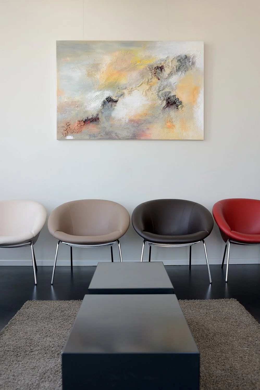Moderner Wartebereich mit Sitzgruppe und Kunstwerk – Unternehmensreportage der Praxisräume in Bonn.