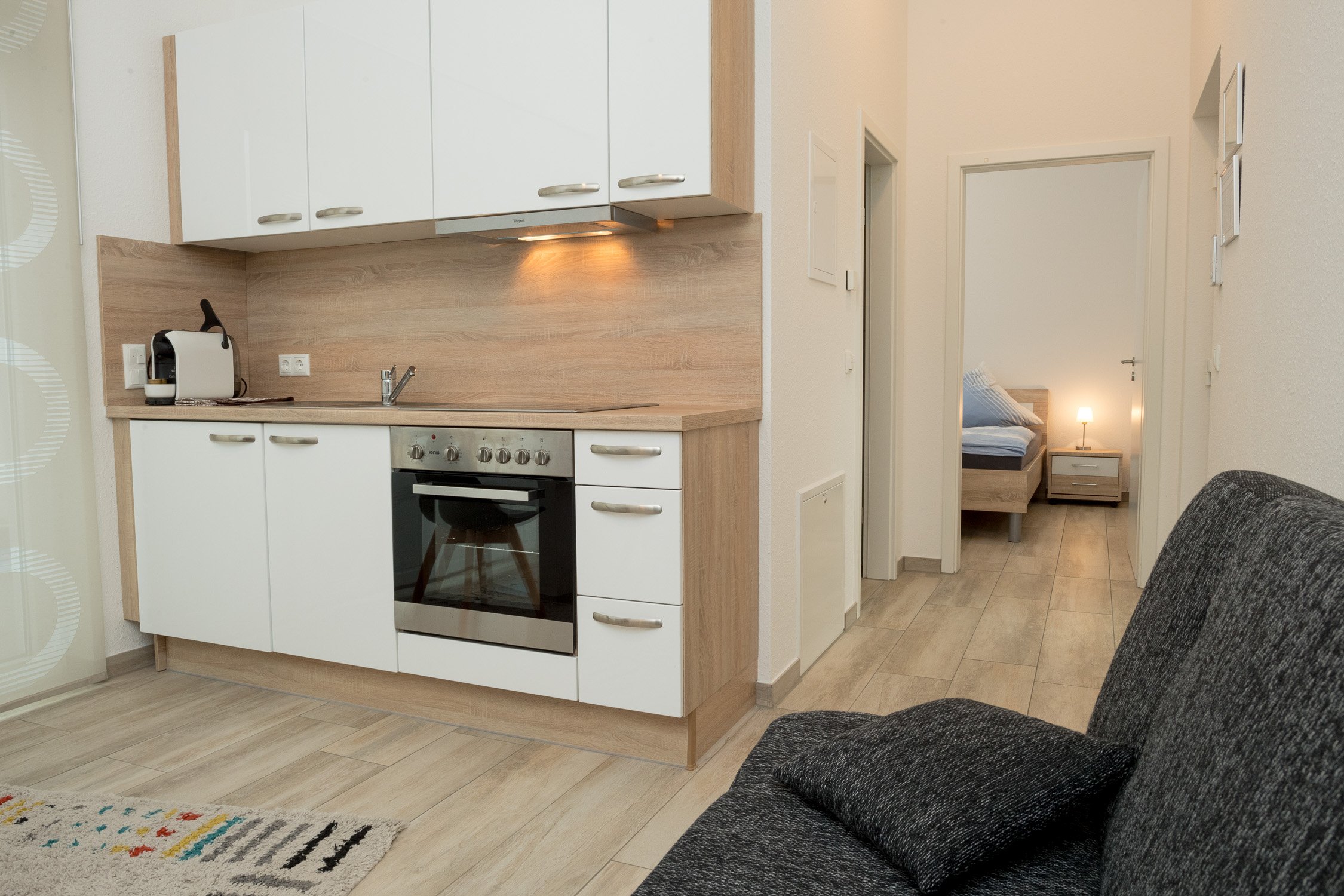 Modernes Apartment mit Küche, Flur und Sofa – Hotelfotografie in Köln.