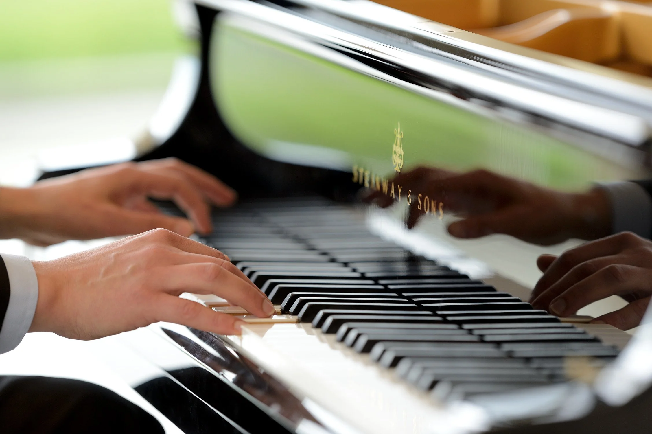 Detailaufnahme von Pianistenhänden am Flügel – stimmungsvolle Businessfotografie in Köln.