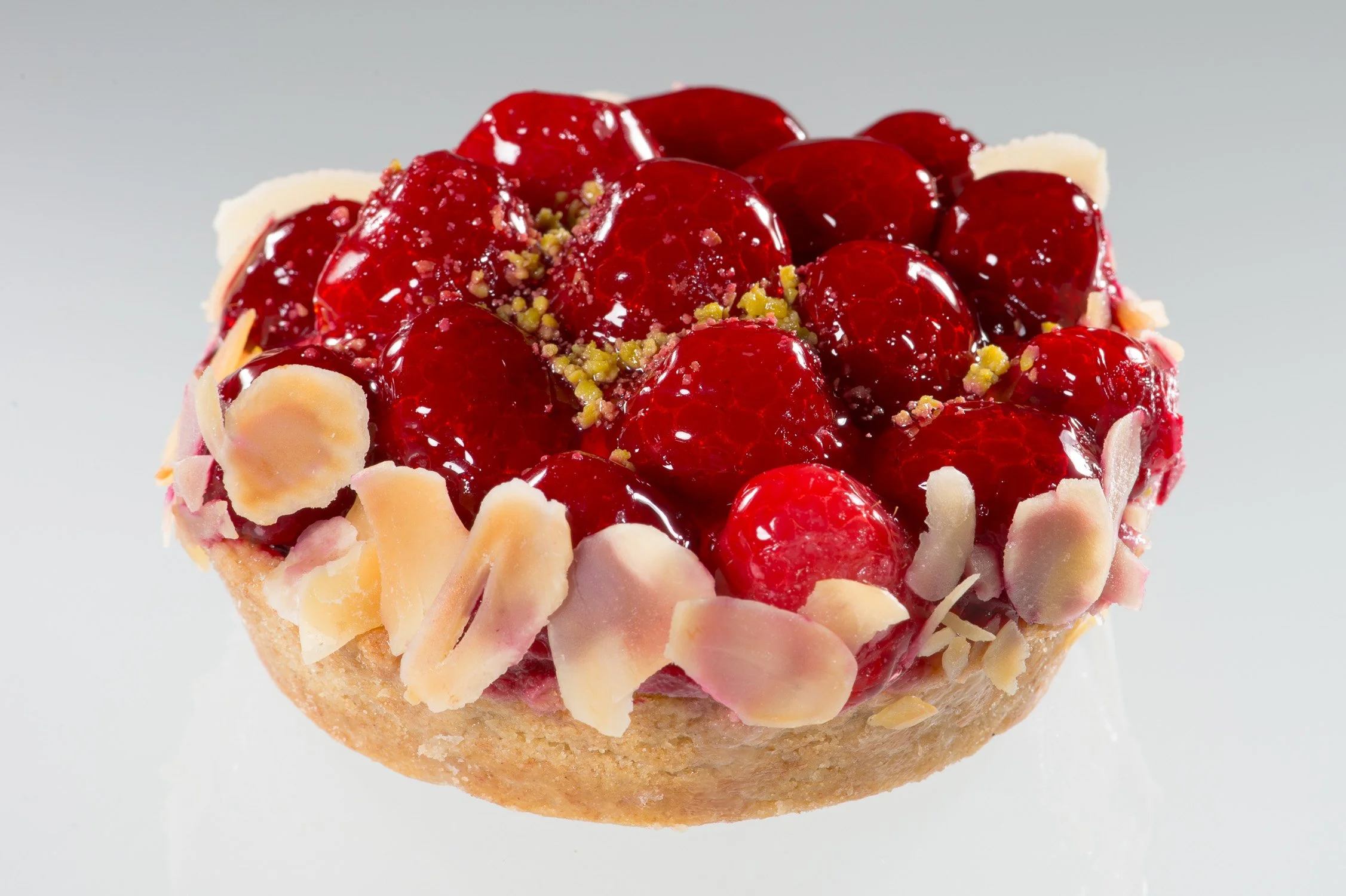 Runde Kirsch-Tarte mit Mandelrand, freigestellt – Food-Produktfotografie für eine Konditorei