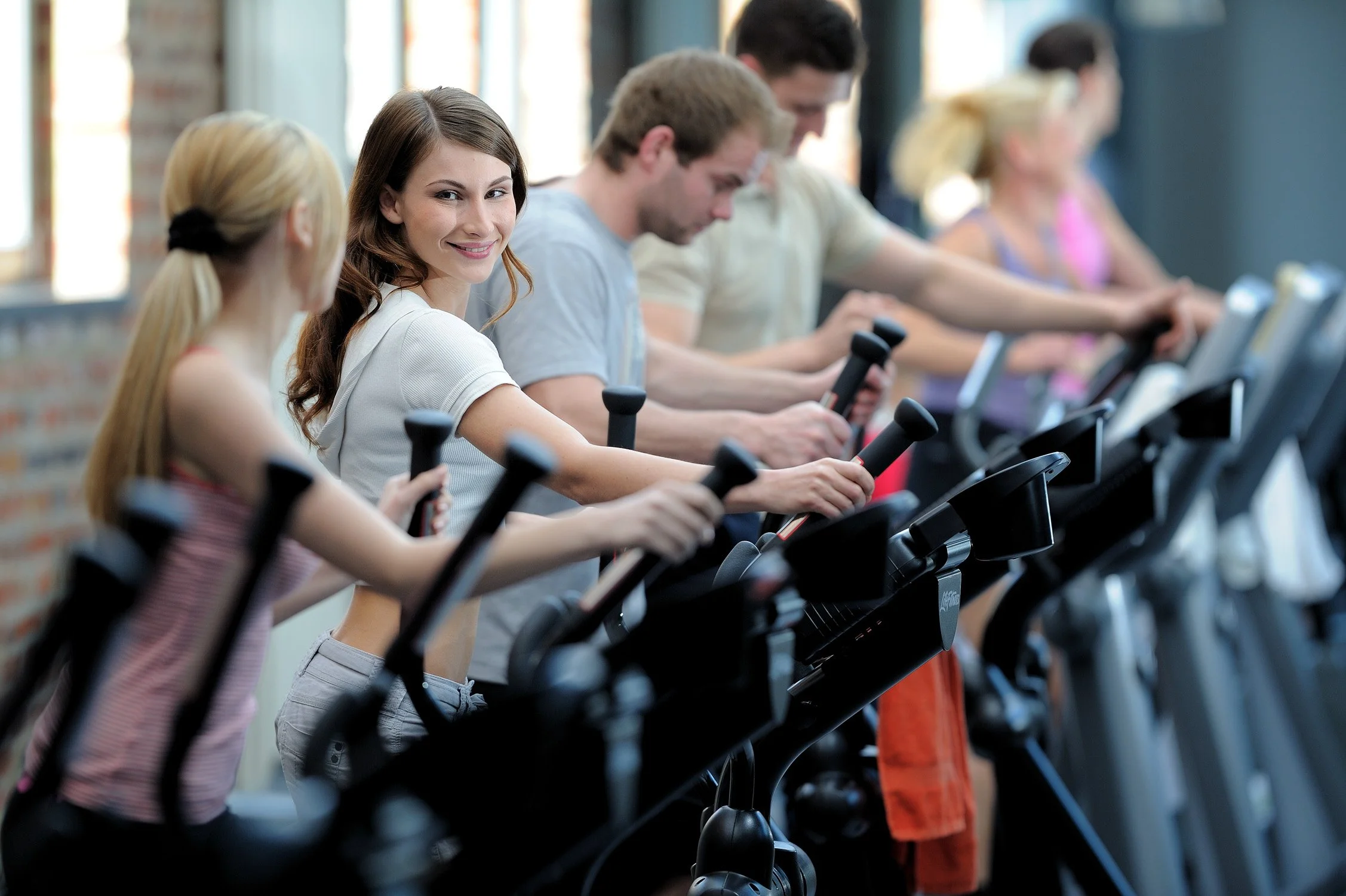 Teilnehmende in einem Indoor-Cycling-Kurs – Unternehmensportrait im Fitnessstudio in Köln und Bonn.