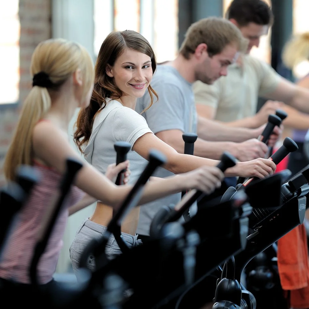 Teilnehmende in einem Indoor-Cycling-Kurs – Unternehmensportrait im Fitnessstudio in Köln und Bonn.