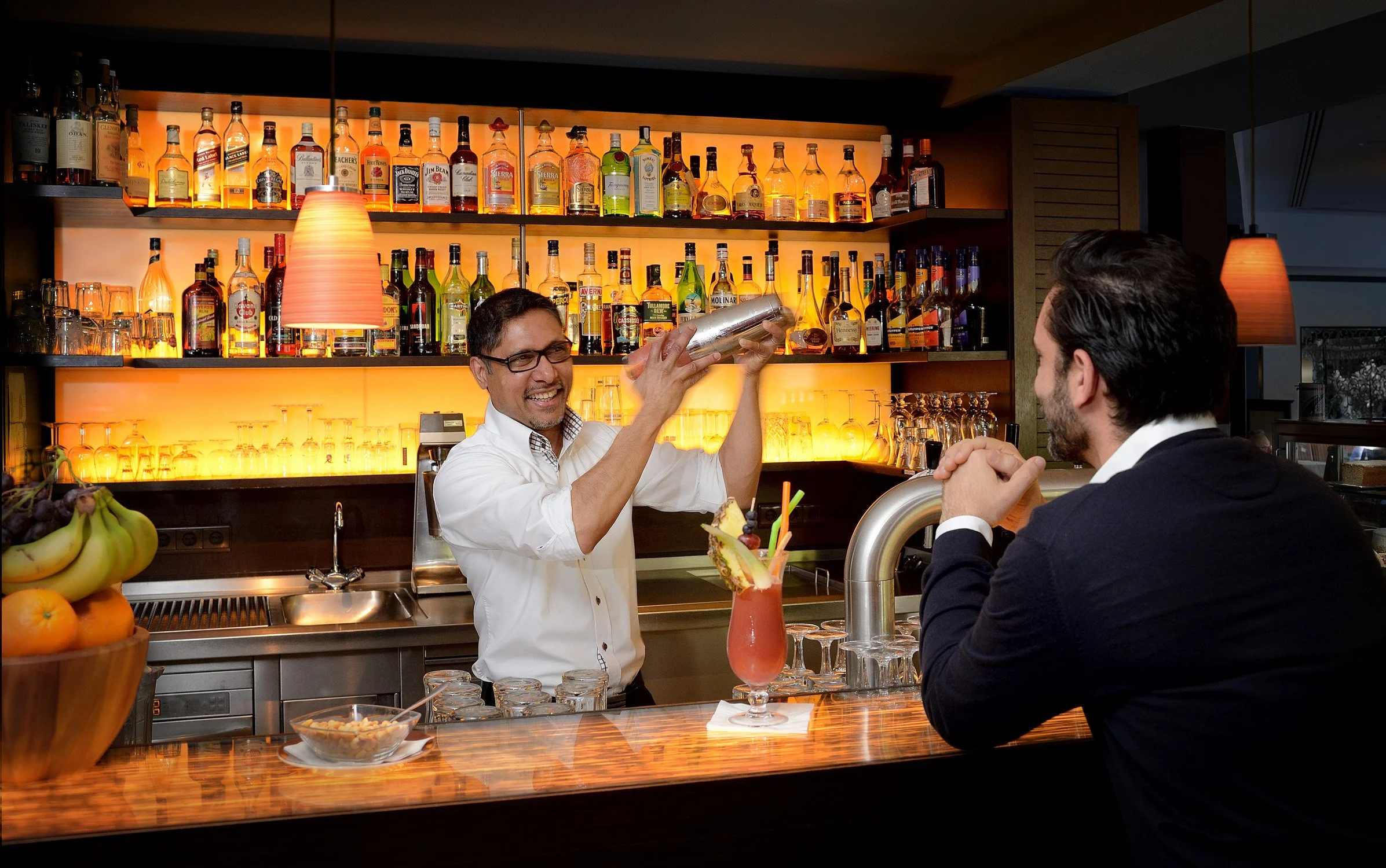 Barkeeper bereitet einen Cocktail an der Hotelbar zu – Hotelbar-Fotografie in Bonn.