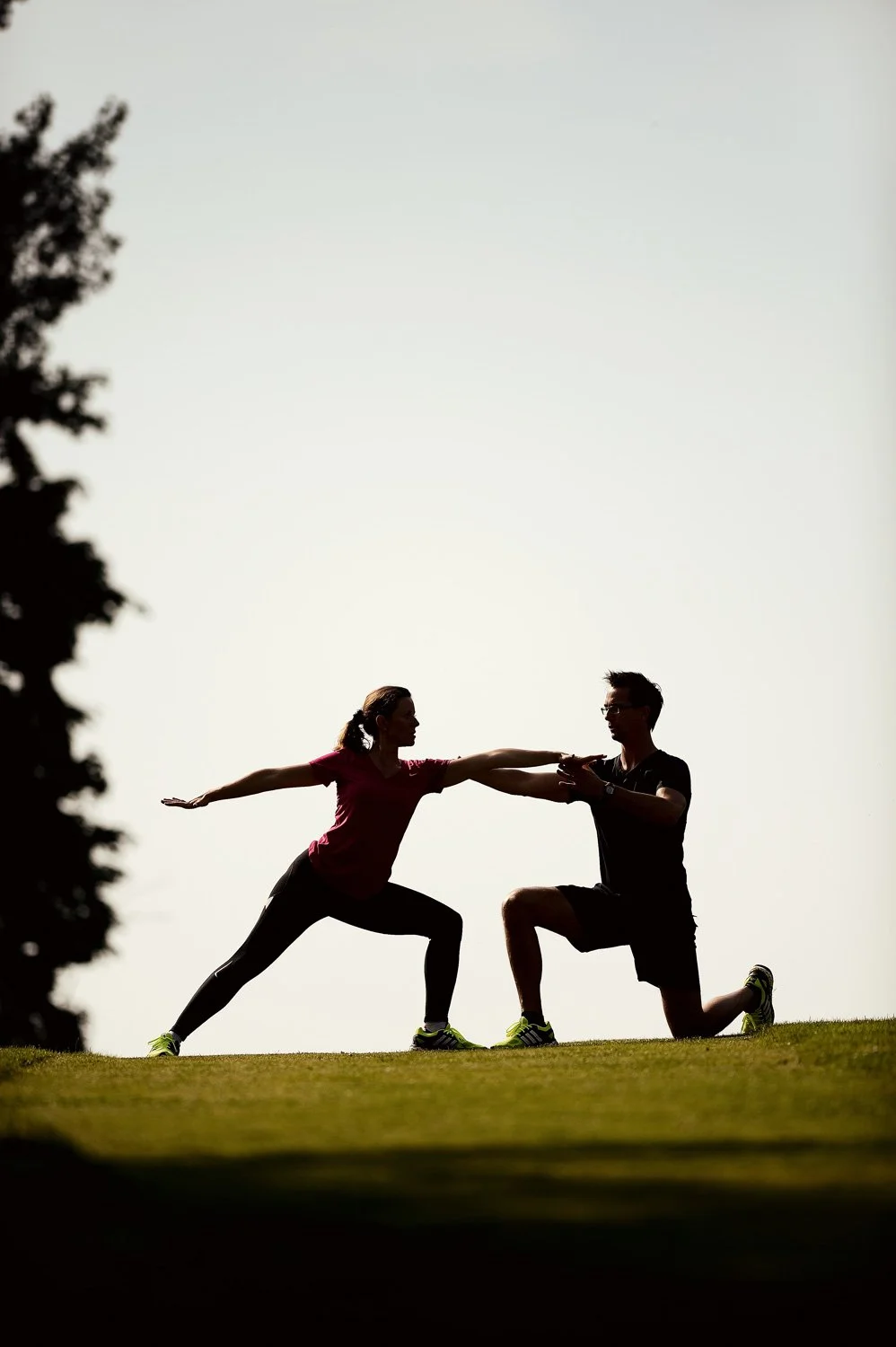 Sportliche Silhouette zweier Menschen im Sonnenuntergang – ausdrucksstarke Businessfotografie.