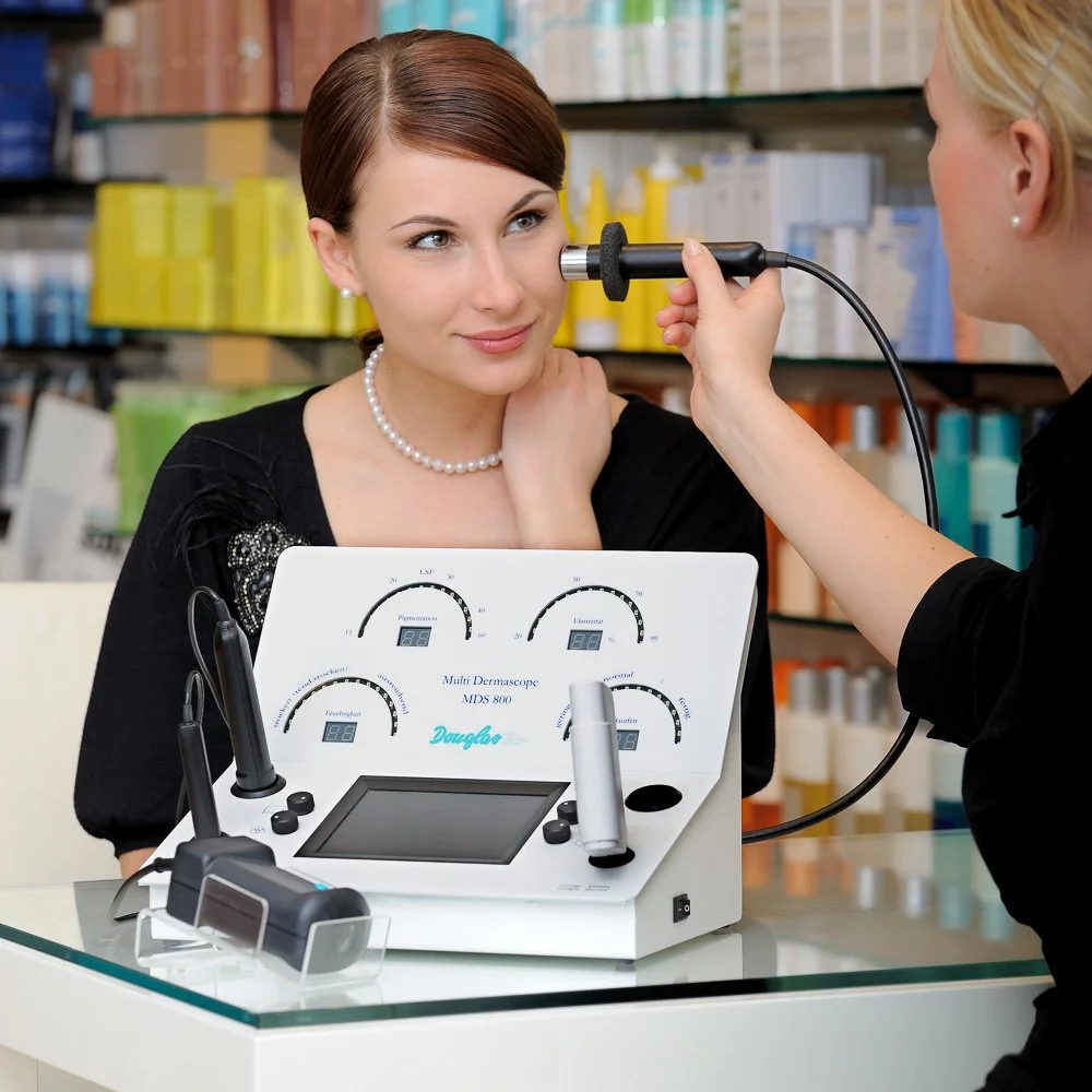 Anwendung eines Hautanalyse-Geräts an einer Kundin – Produkt- und Anwendungsfotografie