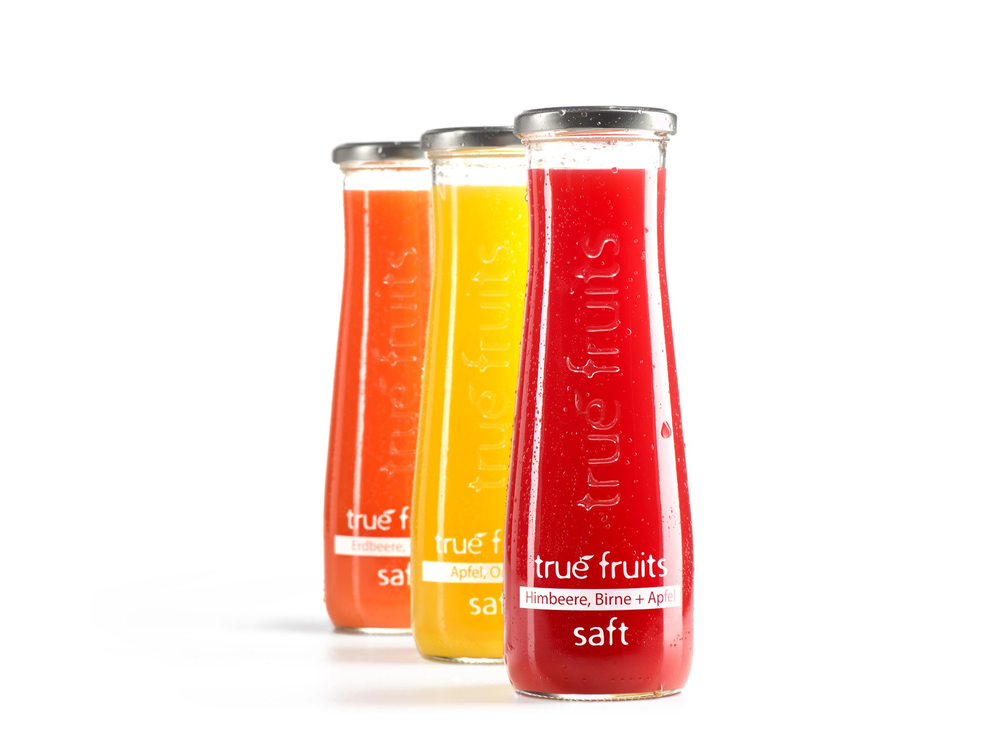 Drei Saftflaschen der Marke true fruits vor weißem Hintergrund – Getränke-Produktfotografie (Packshot)