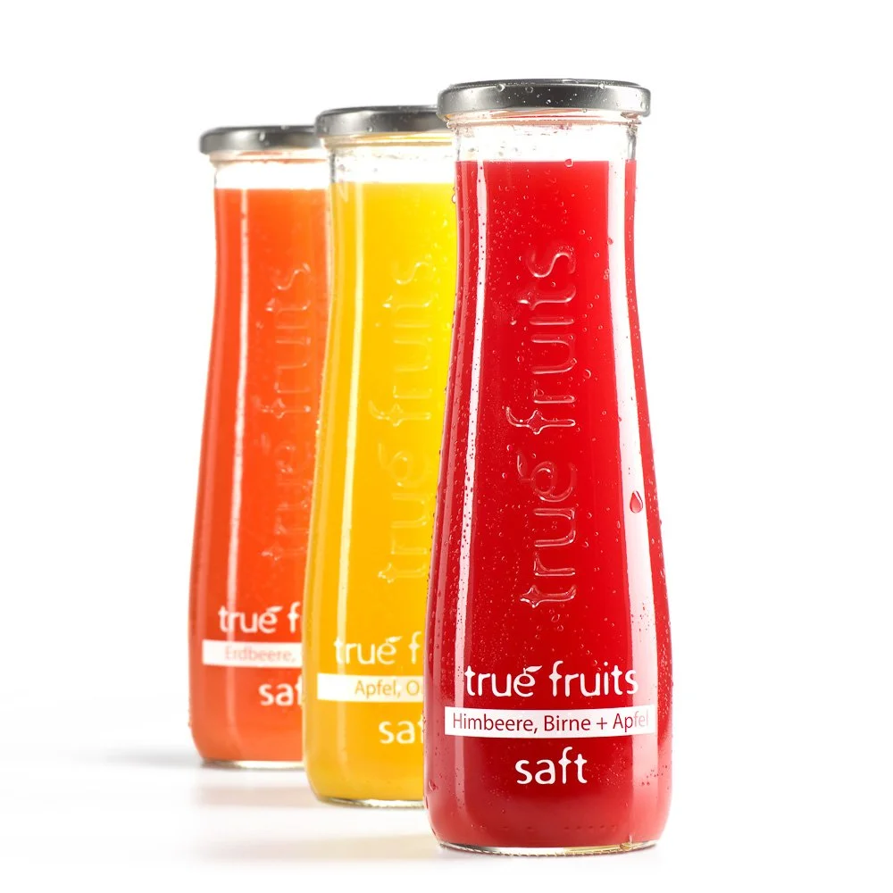 Drei Saftflaschen der Marke true fruits vor weißem Hintergrund – Getränke-Produktfotografie (Packshot)