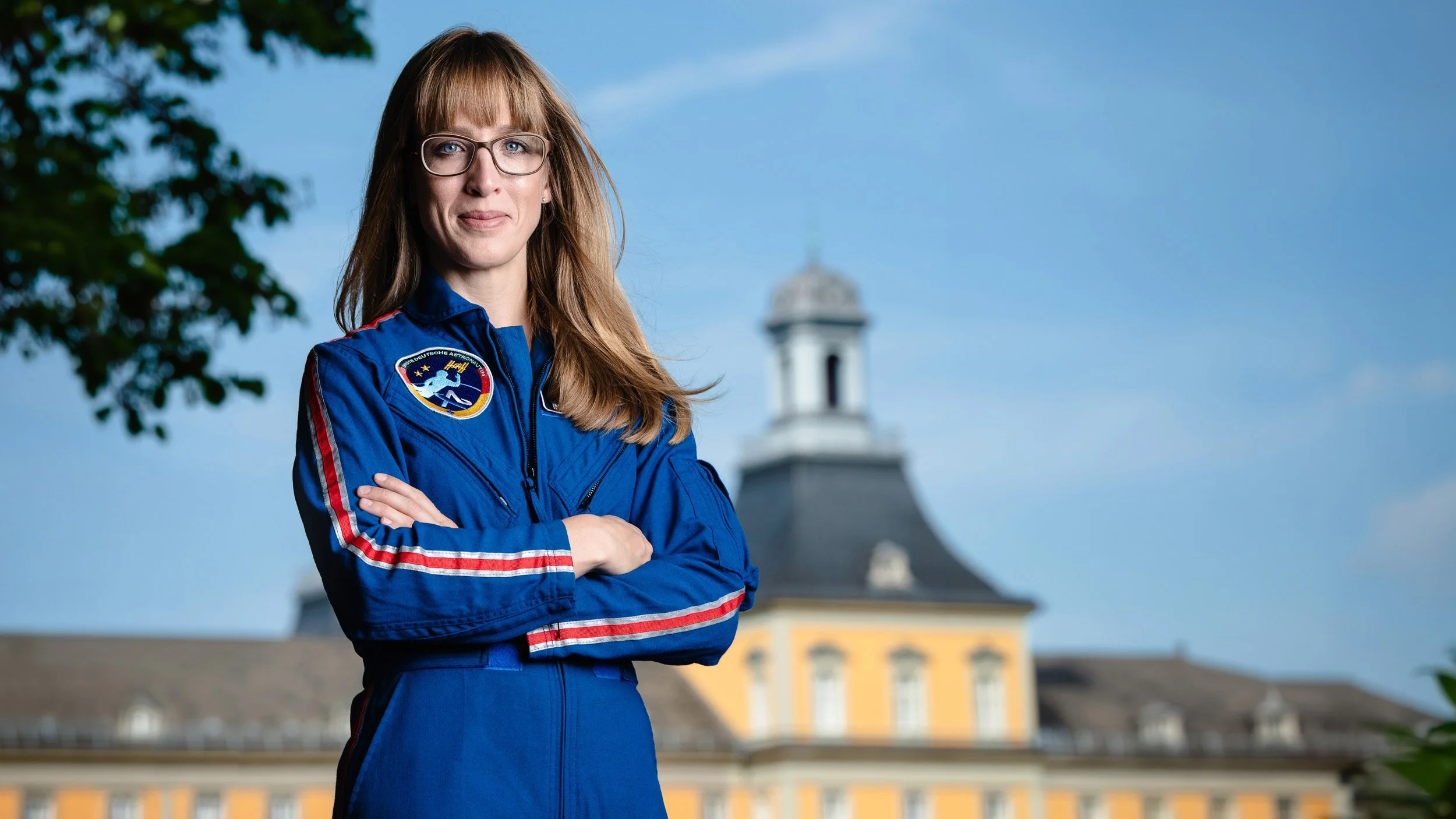 Businessportrait einer Wissenschaftlerin in Arbeitskleidung vor historischem Gebäude in Bonn.