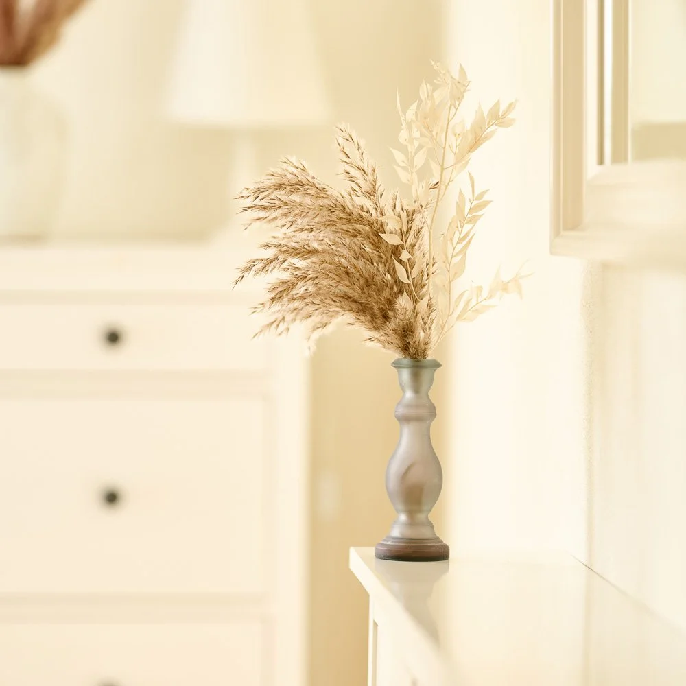 Trockenblumenstrauß in einer Vase auf einer hellen Kommode – Interior- und Produktfotografie