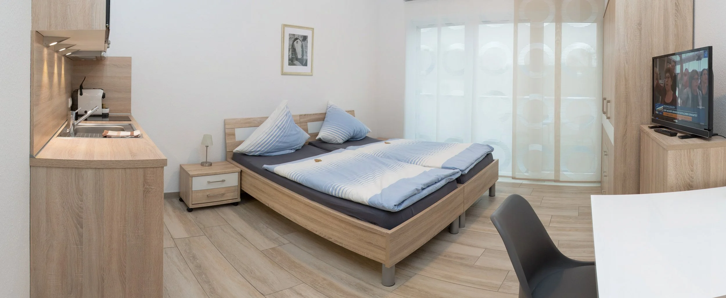 Helles Doppelzimmer mit Bett und Sitzbereich – Hotelzimmer-Fotografie in Bonn.