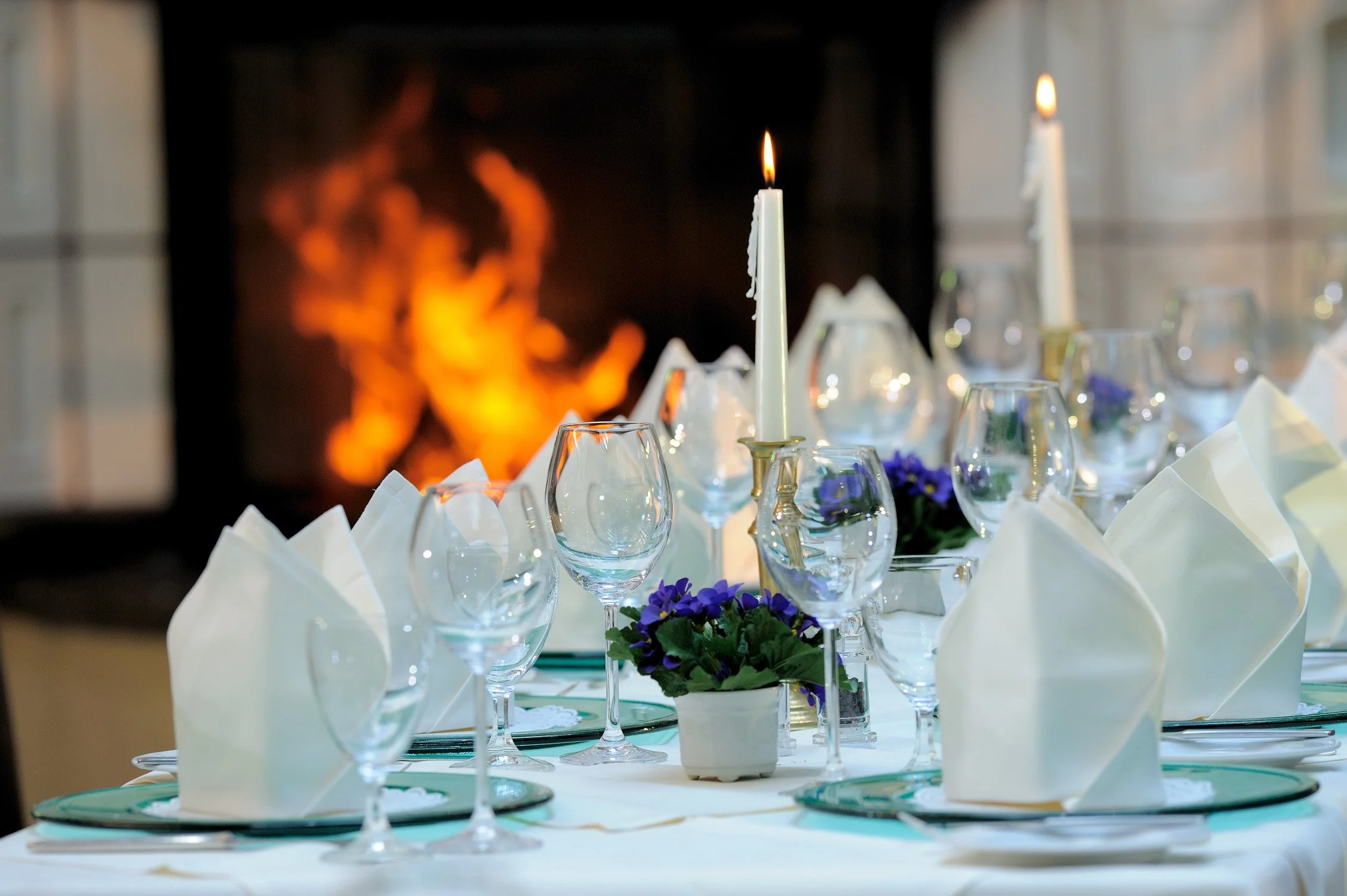 Festlich gedeckte Tafel mit Kaminfeuer im Restaurant – Gastronomiefotografie im Hotel in Siegburg.
