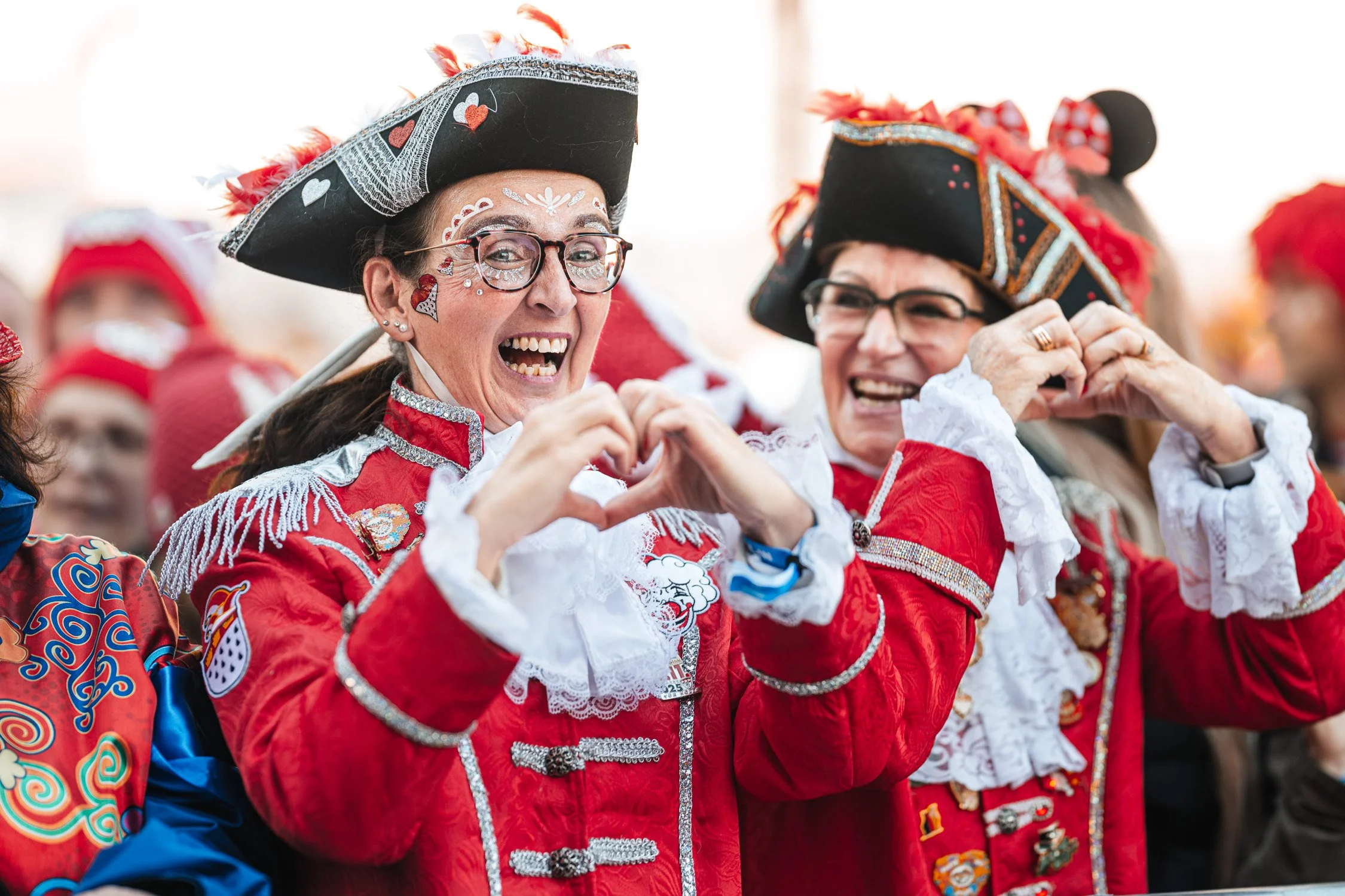 Zwei Gardisten in roter Uniform formen mit den Händen ein Herz.