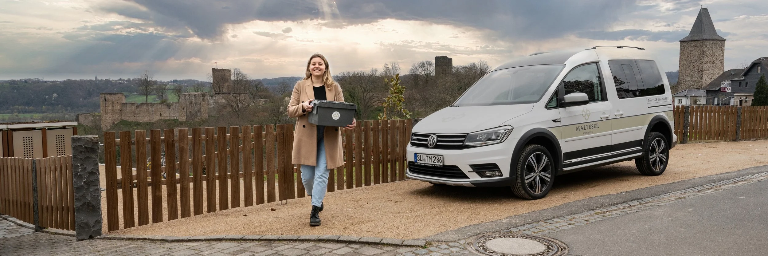 Mitarbeiterin mit Firmenwagen im mobilen Einsatz mit Blick über die Region – Unternehmensportrait in Köln und Bonn.