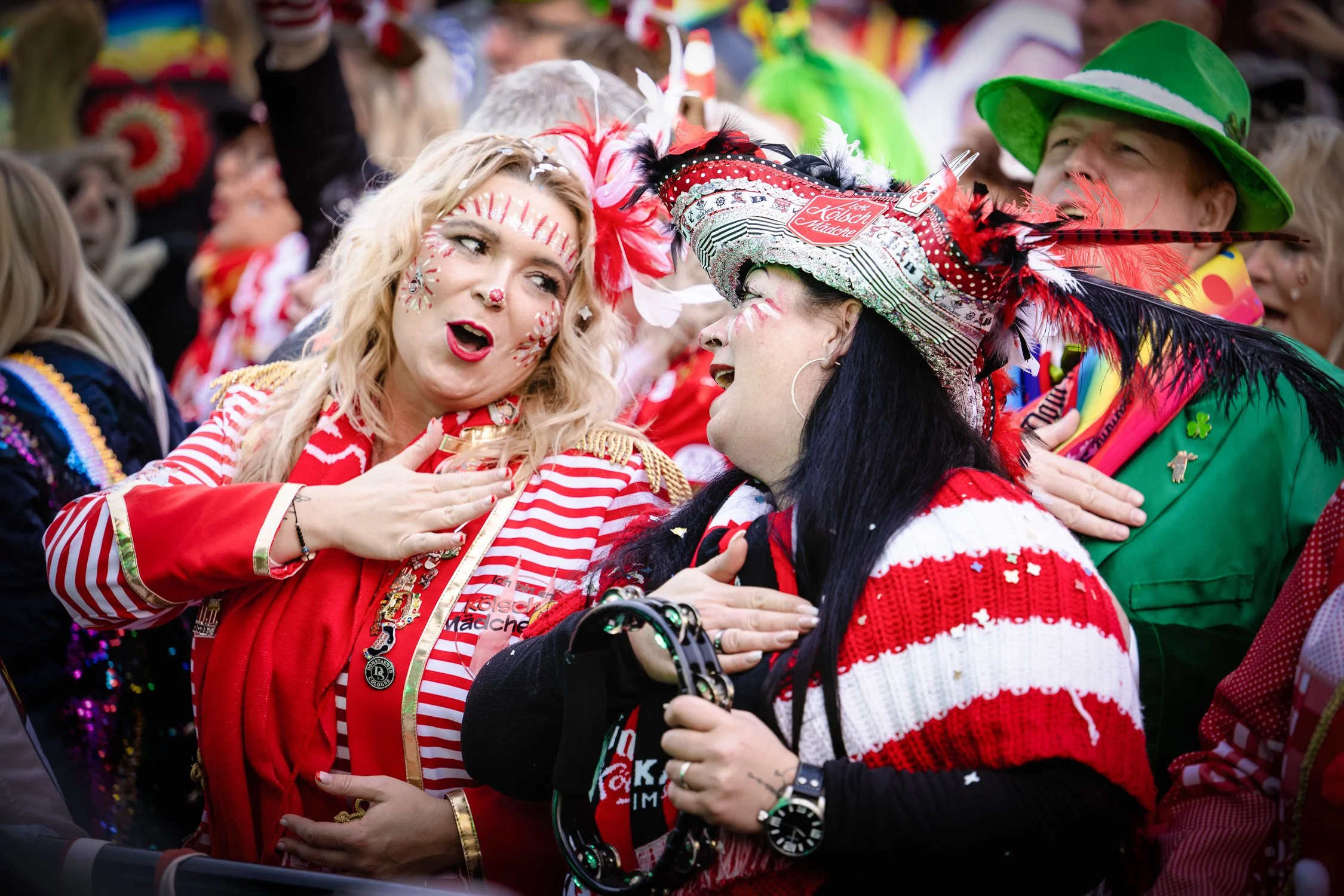 Feiernde Jecken in rot-weißen Kostümen beim Kölner Karneval.