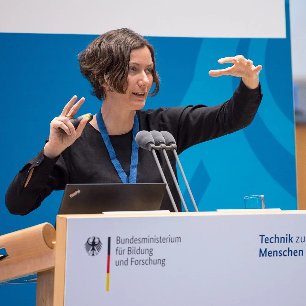 Rednerin am Podium des Bundesministeriums für Bildung und Forschung.