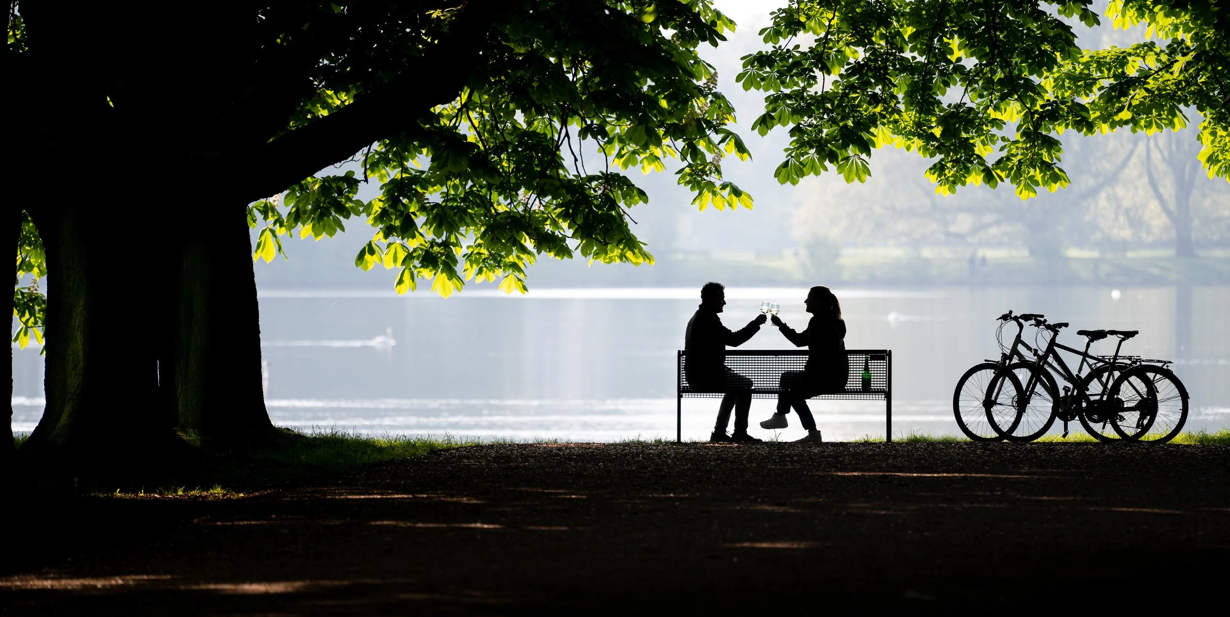 Paar stößt bei malerischem Abendlicht am See an – Tourismus- und Hotelfotografie zur Umgebung in Köln.