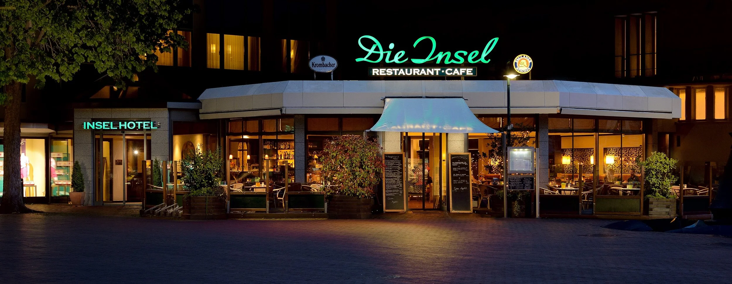 Beleuchtete Außenansicht eines Hotels mit Restaurant-Café am Abend – Hotelfotografie in Bonn.