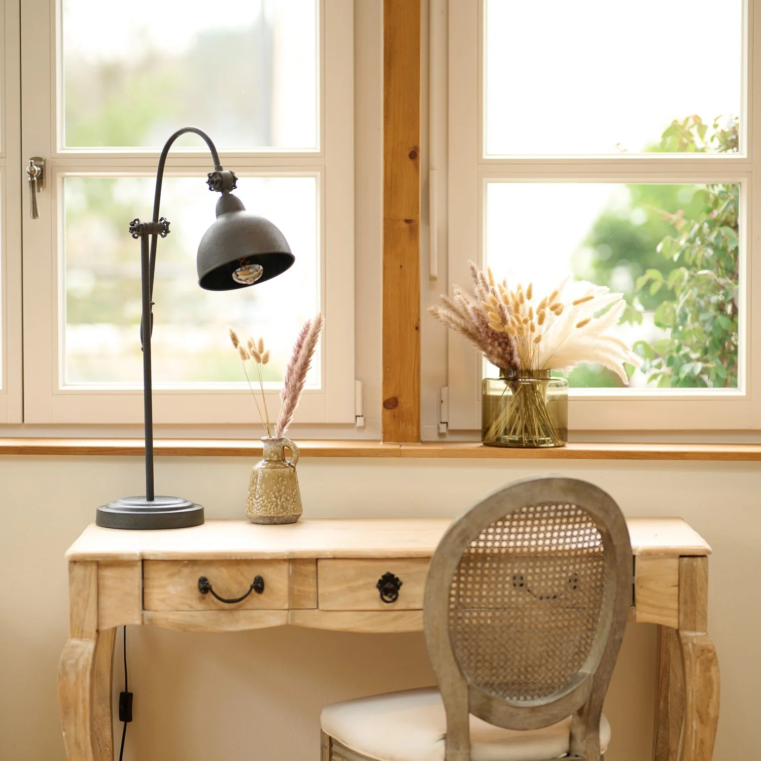 Vintage-Holzschreibtisch mit Lampe und Stuhl am Fenster, Trockengräser in einer Vase – Interior-Fotografie