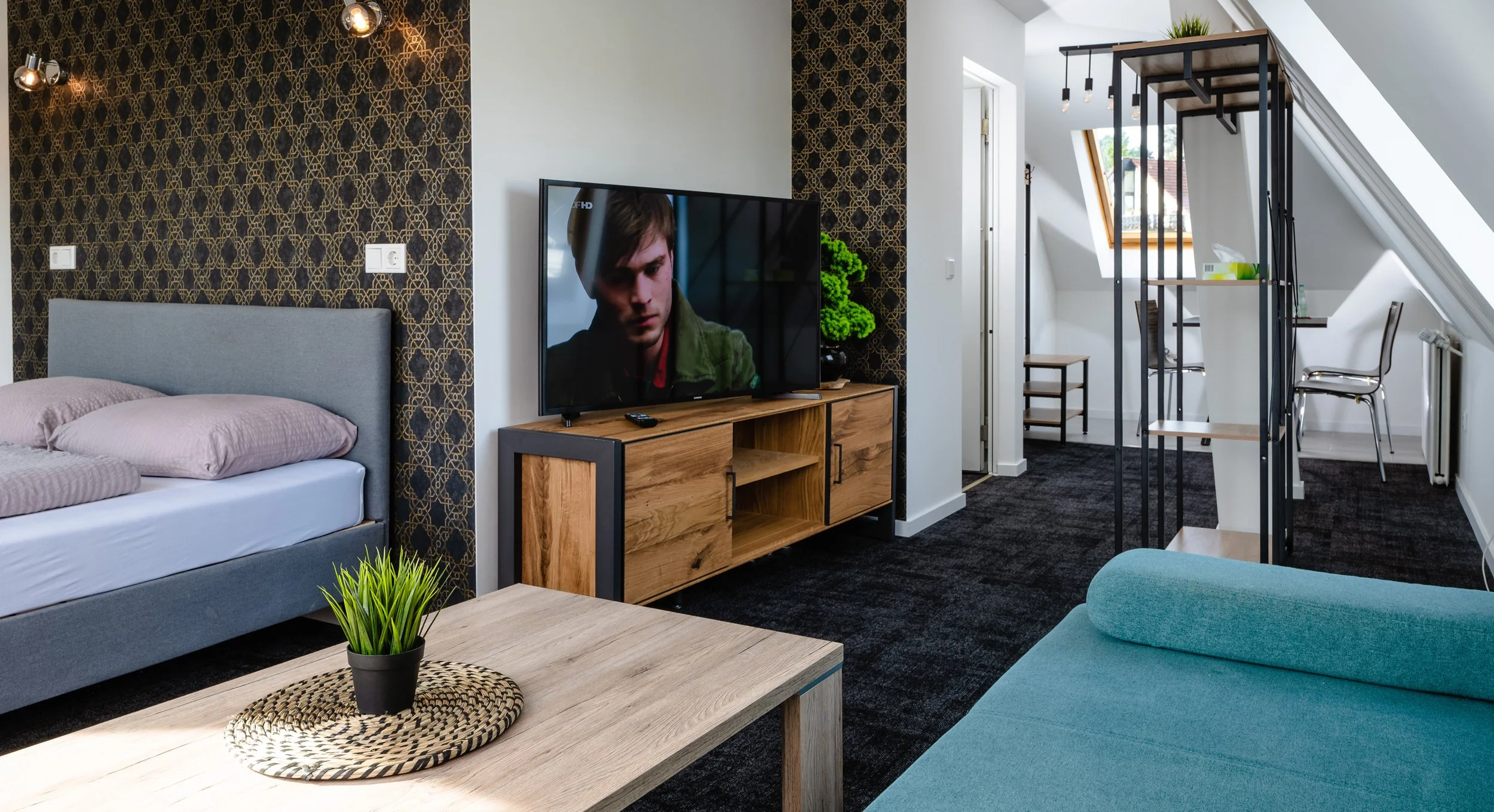 Maisonette-Zimmer mit Bett, Fernseher und Galerieebene – Hotelzimmer-Fotografie in Köln.
