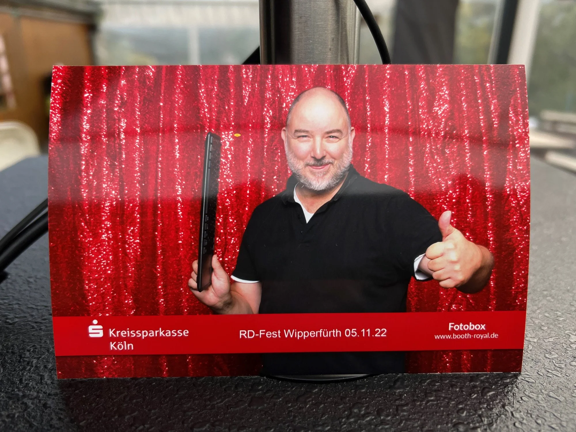 Gast hält einen frischen Papierabzug aus der Fotobox in der Hand